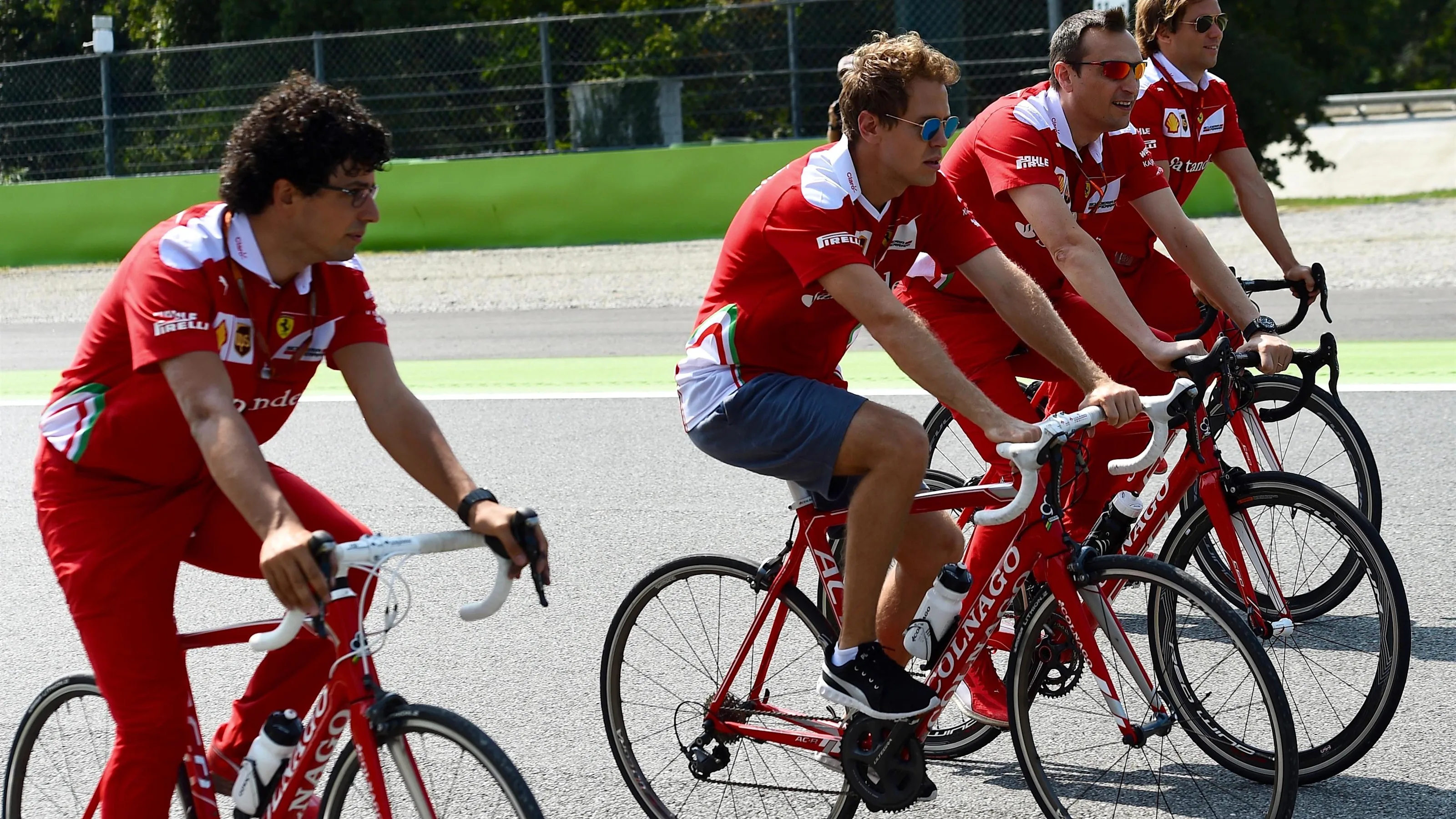 Sebastian Vettel (GER) Ferrari rides the track on a bike with Riccardo Adami (ITA) Ferrari Race