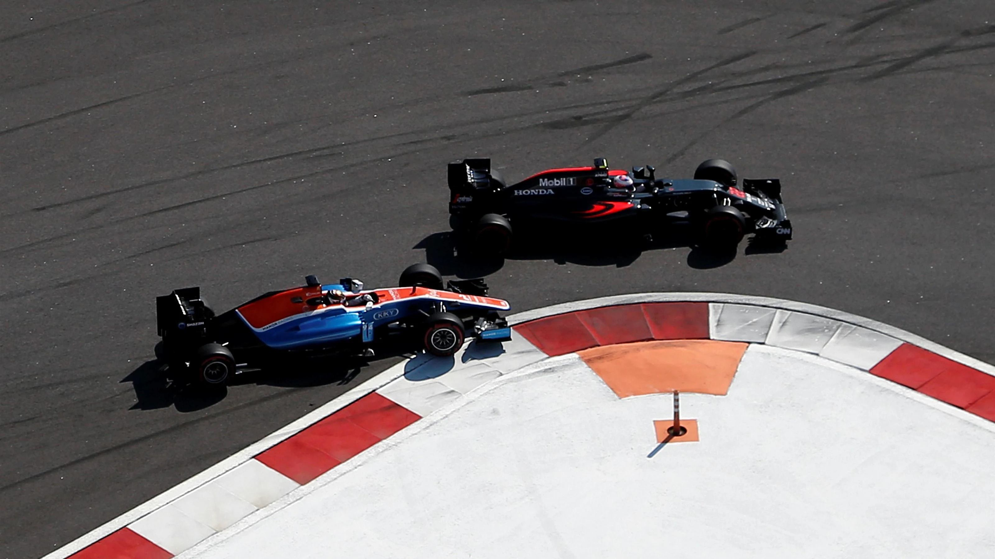 Jenson Button (GBR) McLaren MP4-31 and Pascal Wehrlein (GER) Manor Racing MRT05 battle at Formula