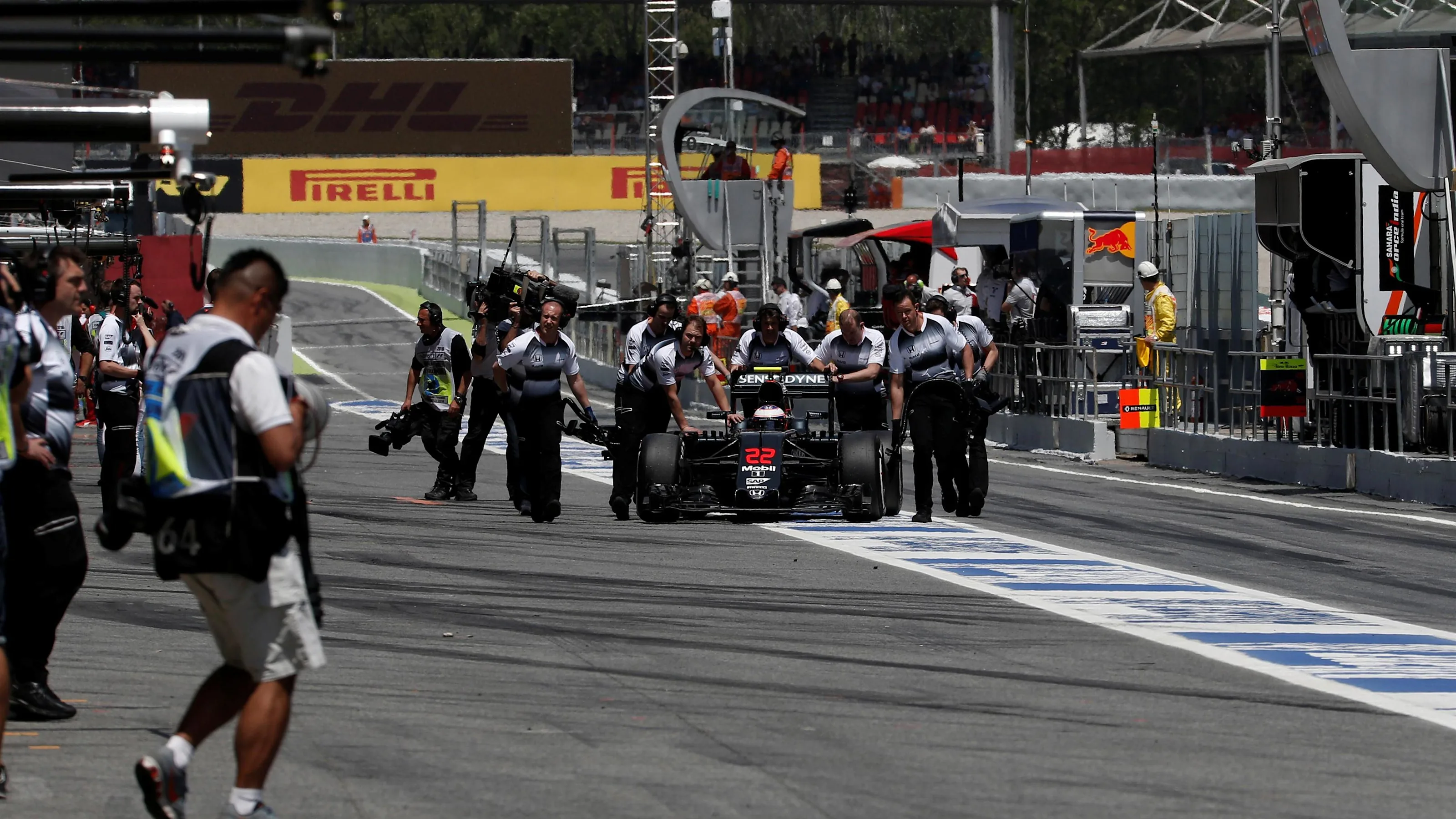 Jenson Button (GBR) McLaren MP4-31 is pushed in pit lane by the McLaren mechanics after stopping in