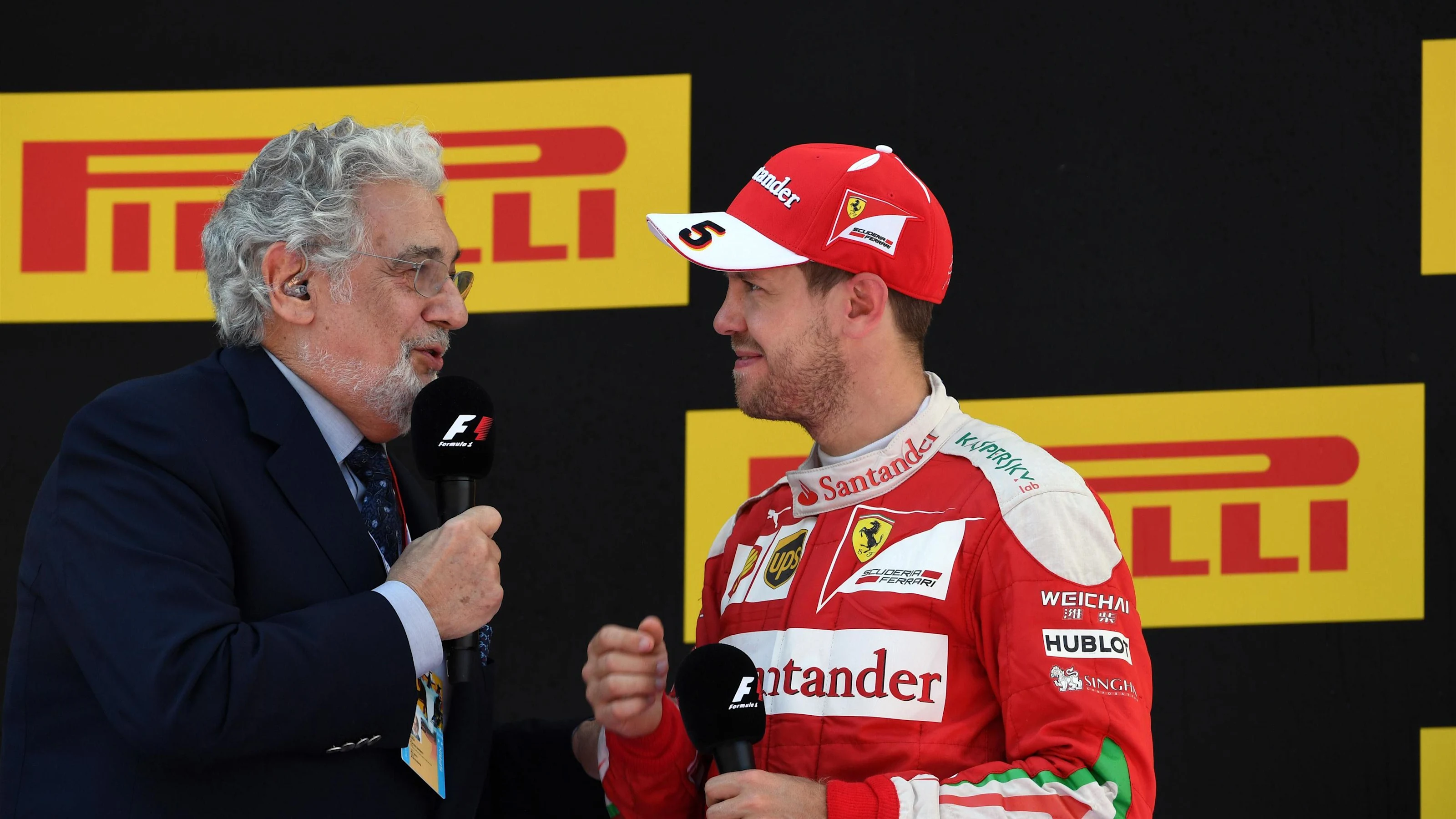 Placido Domingo (ESP) celebrates on the podium with Sebastian Vettel (GER) Ferrari at Formula One