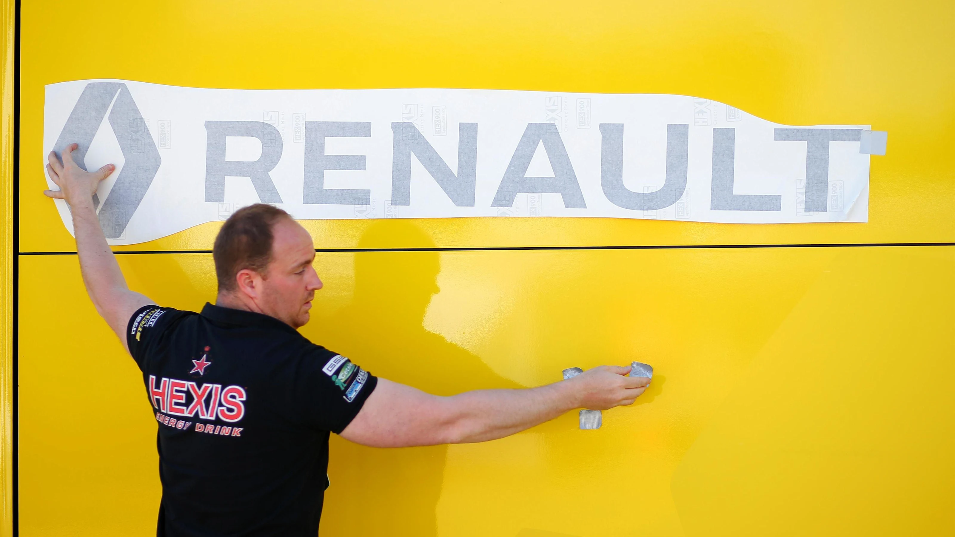 Renault Sport F1 Team mechanic applies a Renault Sport F1 Team logo at Formula One World