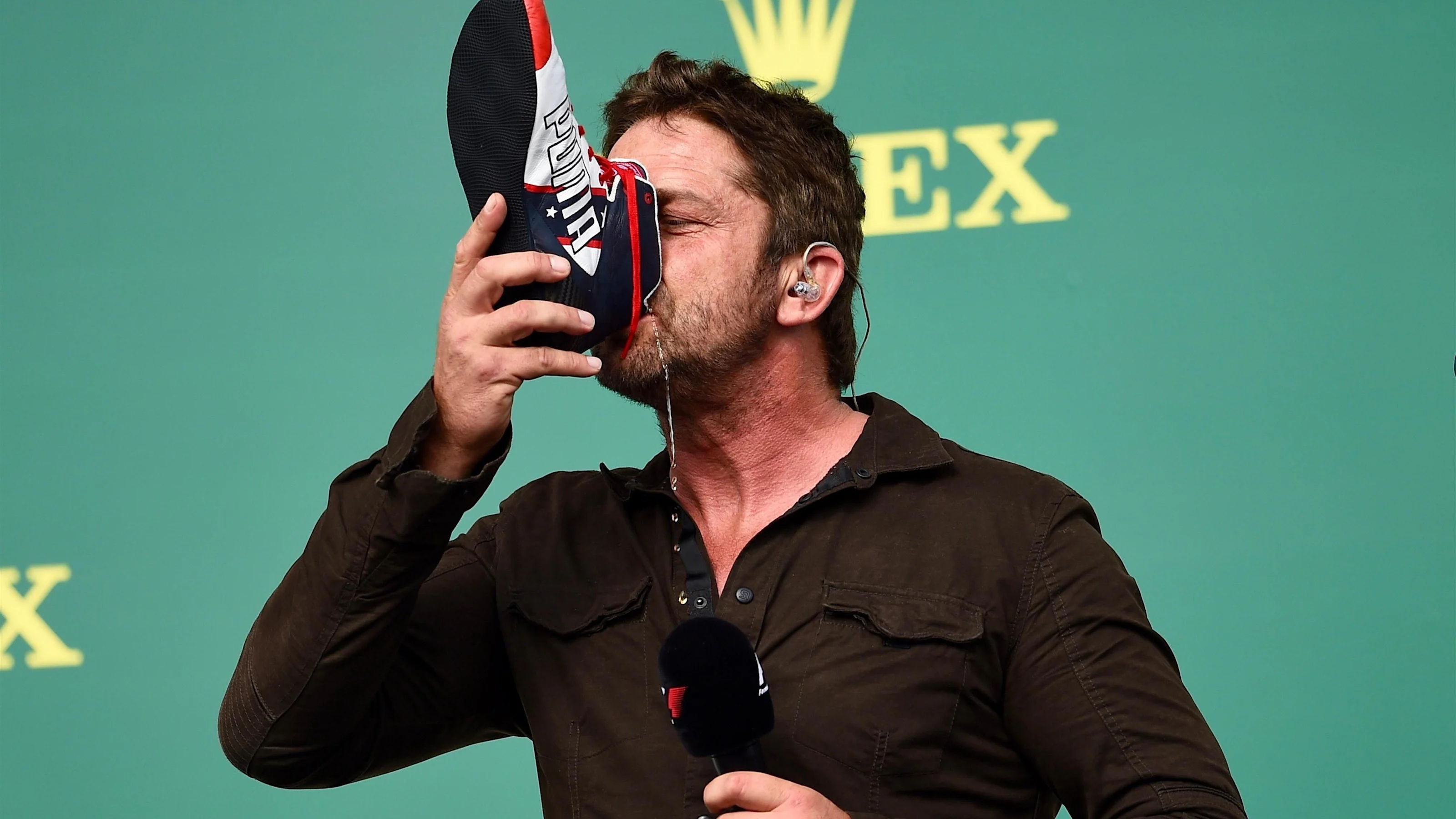 Gerard Butler (GBR) Actor drinks from the boot of Daniel Ricciardo (AUS) Red Bull Racing on the