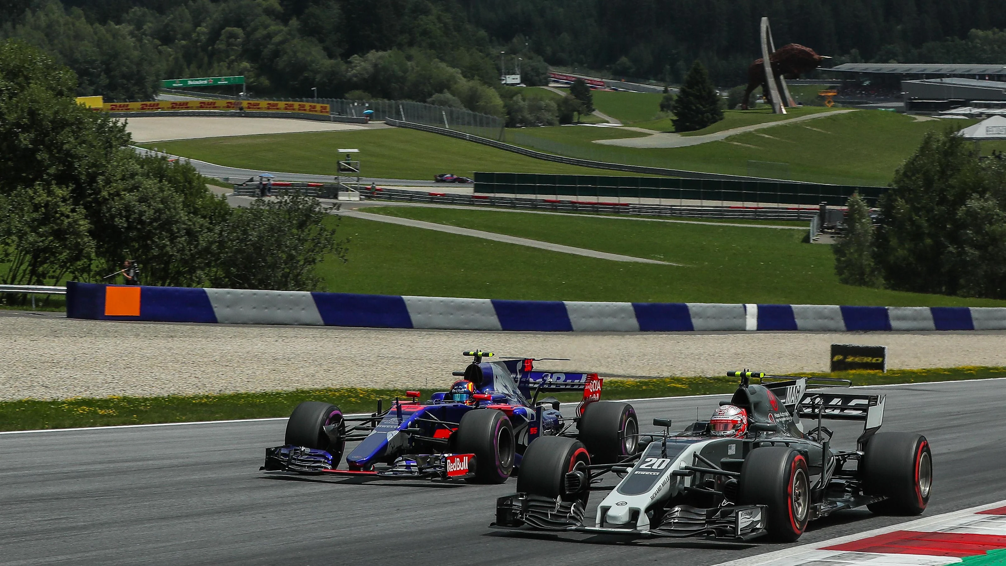 Kevin Magnussen (DEN) Haas VF-17 and Carlos Sainz jr (ESP) Scuderia Toro Rosso STR12 battle for