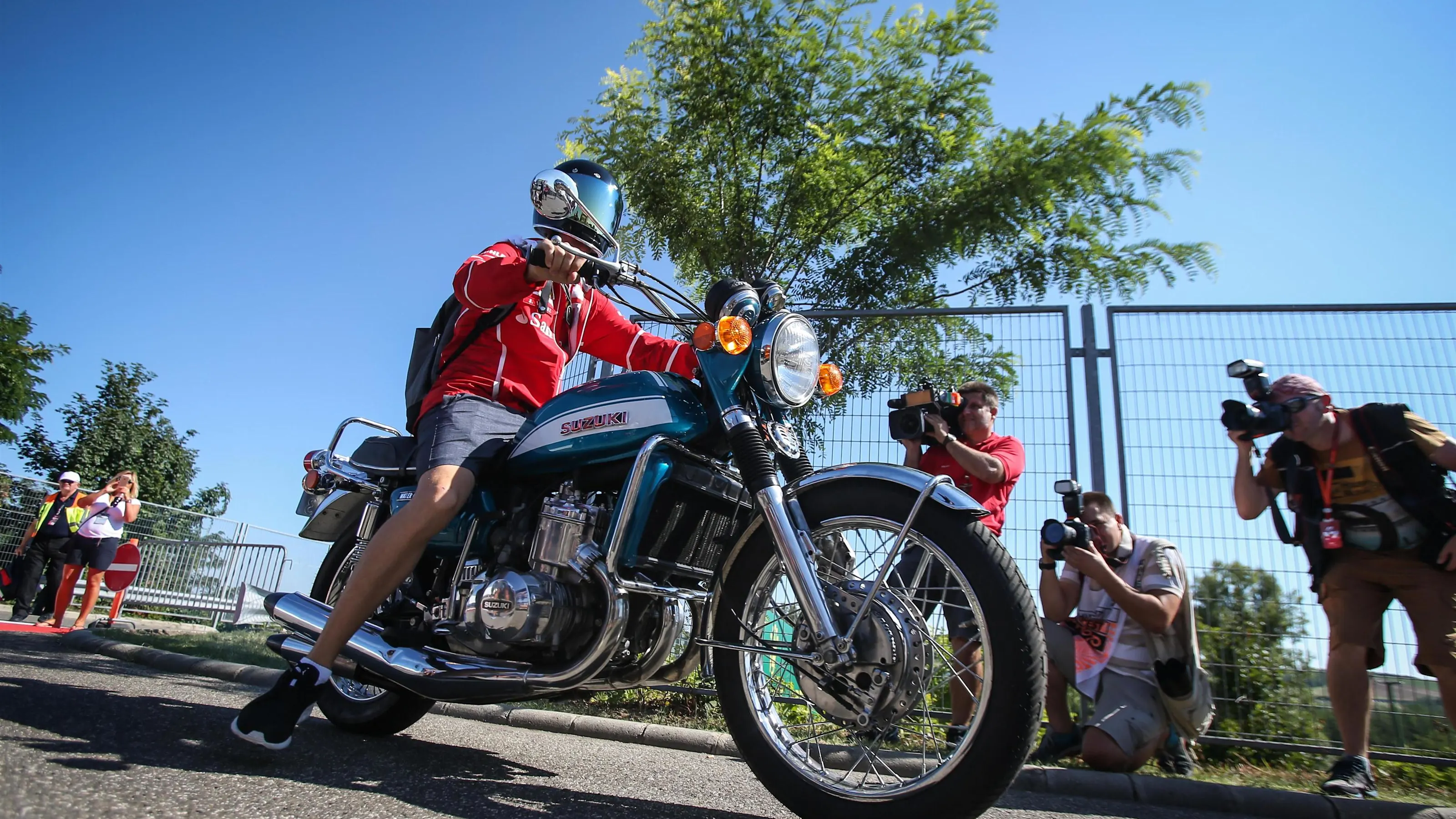 Sebastian Vettel (GER) Ferrari arrives on his Suzuki 750 motorbike at Formula One World