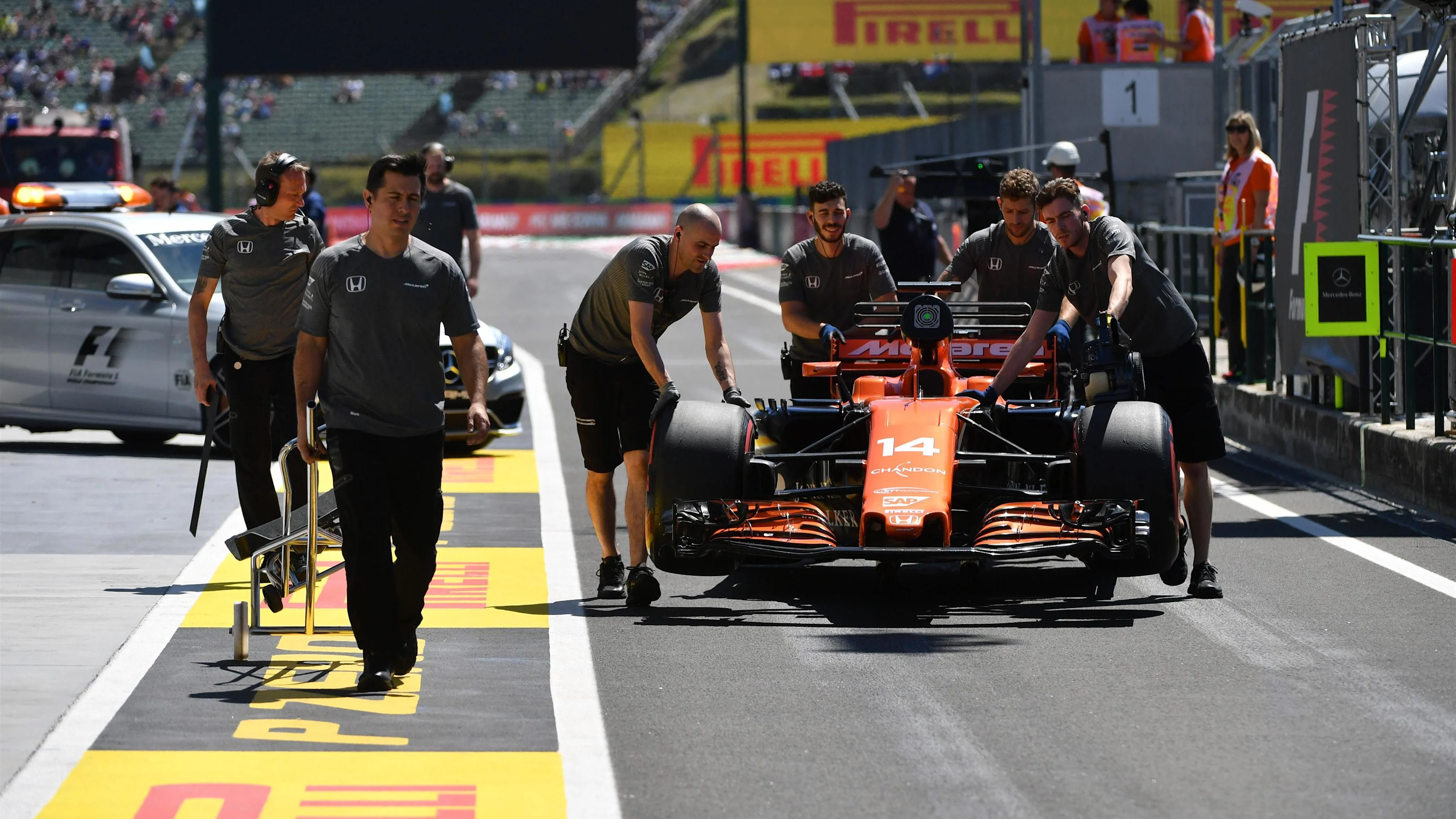 McLaren mechanics push the car of Fernando Alonso (ESP) McLaren MCL32 in pit lane at Formula One
