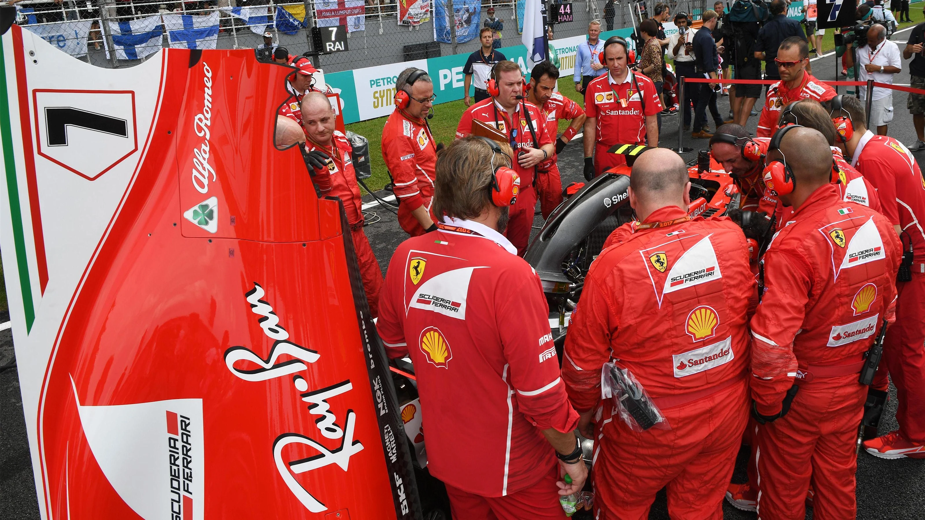 Ferrari attend to a problem on the car of Kimi Raikkonen (FIN) Ferrari SF70-H on the grid at