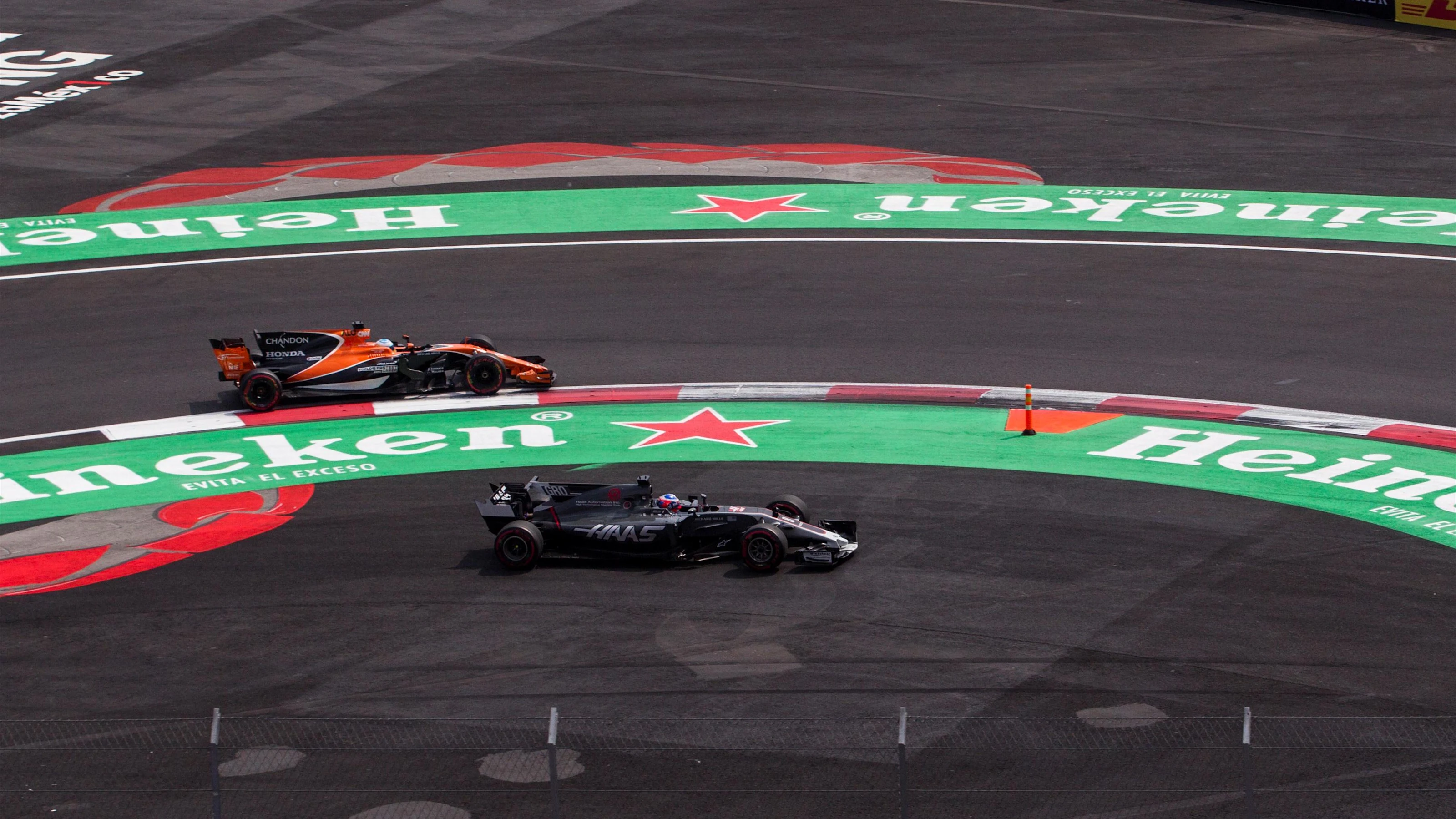 Romain Grosjean (FRA) Haas VF-17 runs wide alongside Fernando Alonso (ESP) McLaren MCL32 at Formula