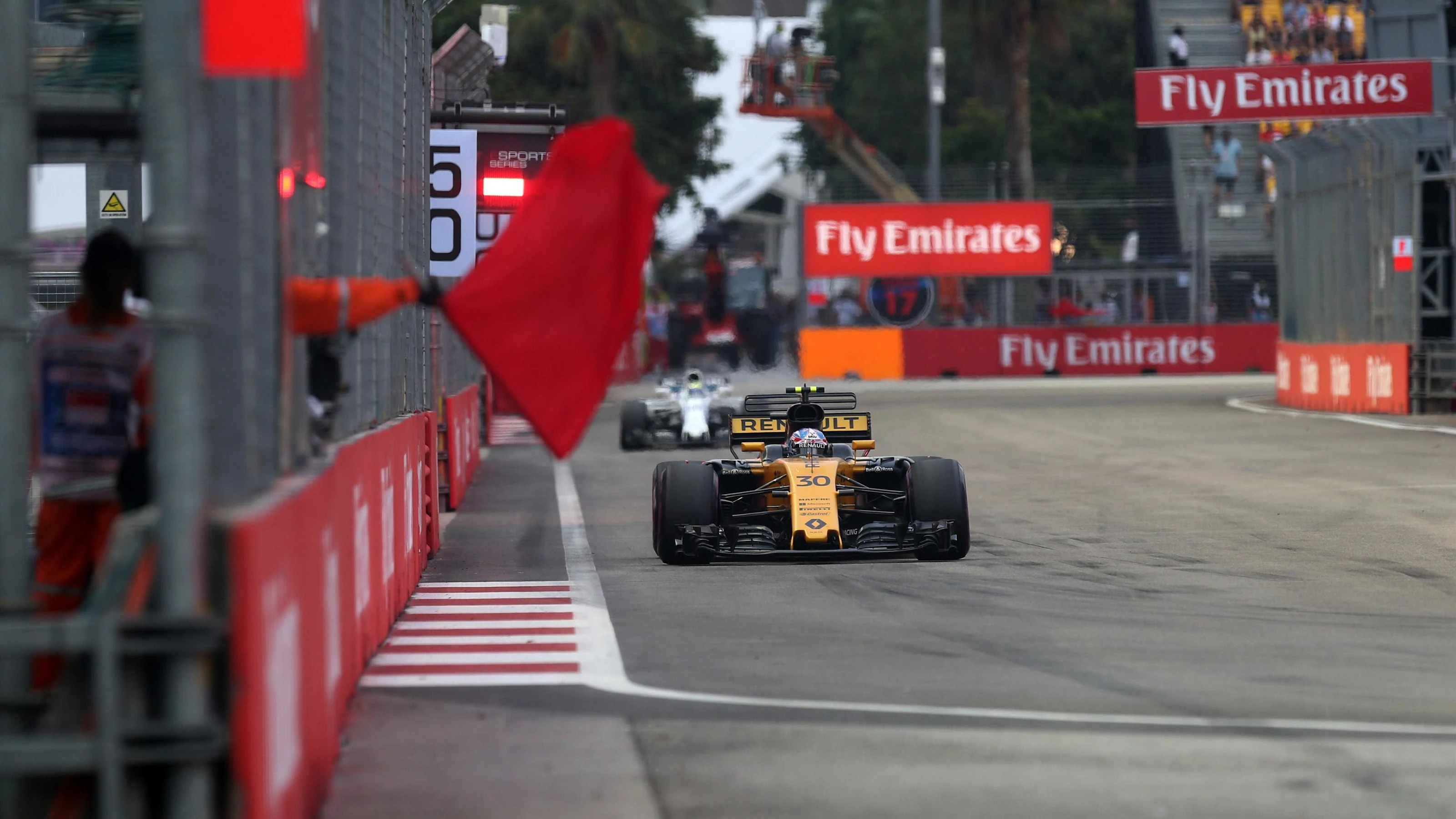 Jolyon Palmer (GBR) Renault Sport F1 Team RS17 and Marshal waves a red flag in FP3 at Formula One