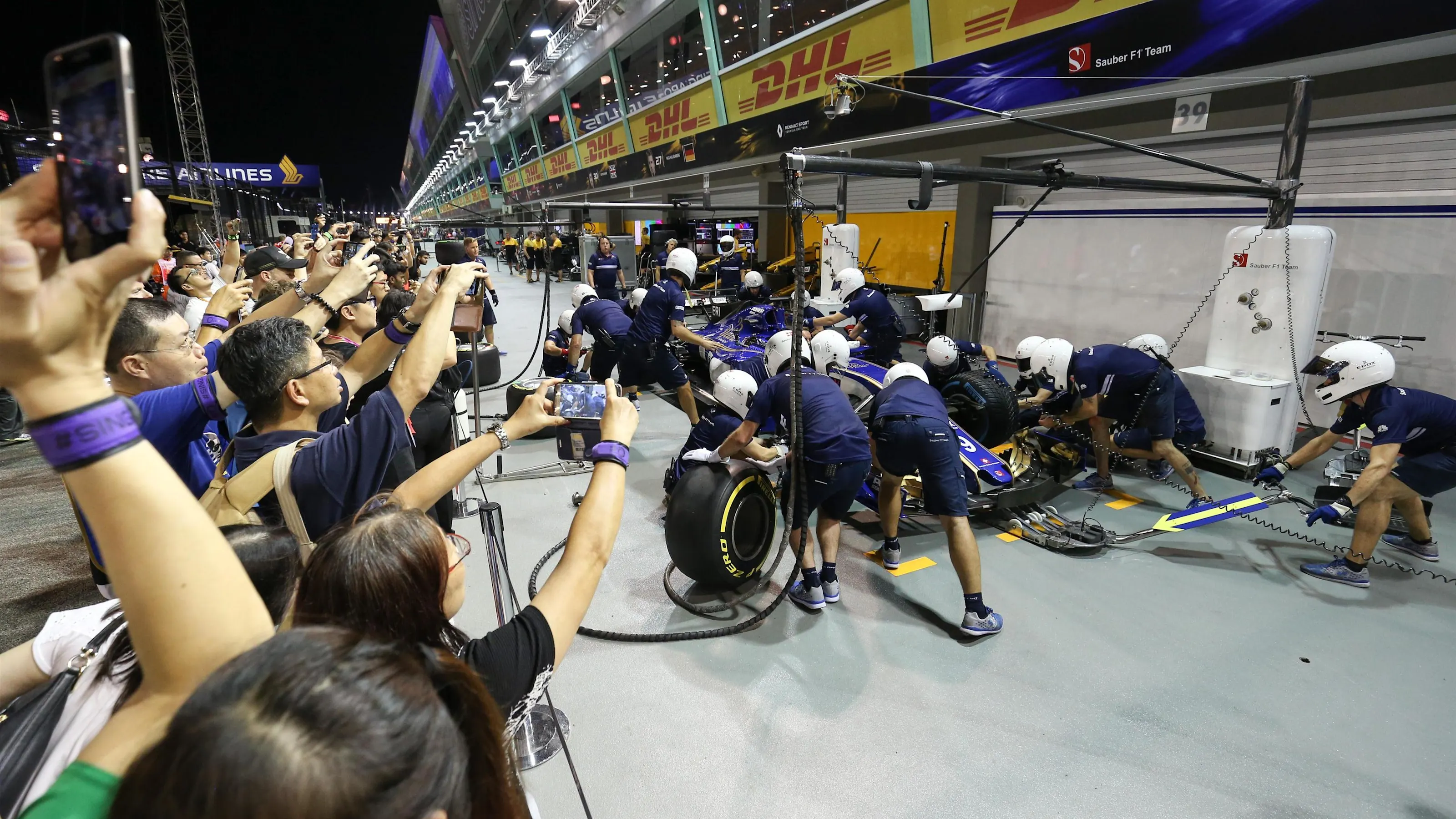 Fans on the pitlane walkabout observe Sauber mechanics make a practice pitstop at Formula One World