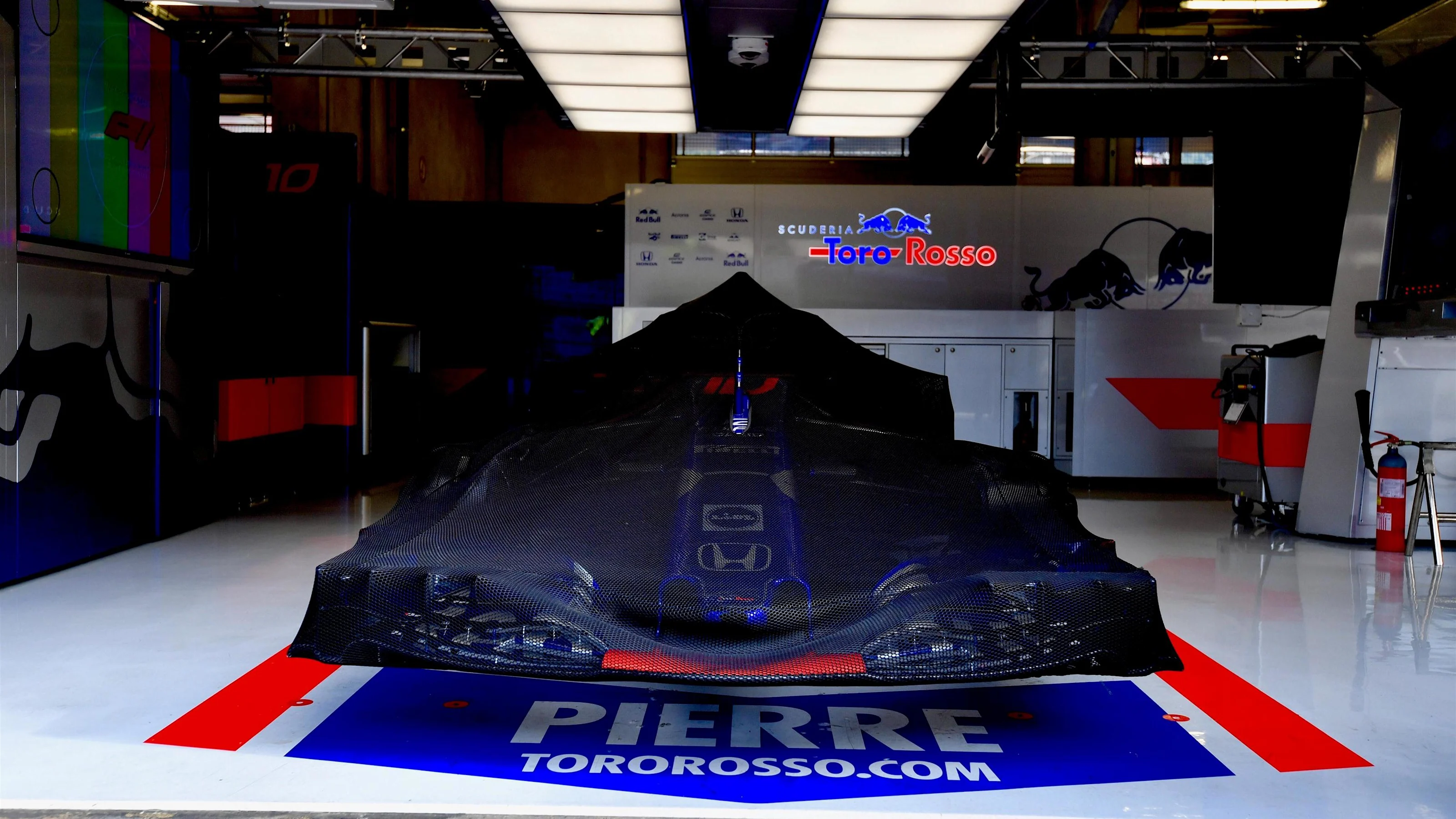 Scuderia Toro Rosso STR13 under covers in the garage at Formula One World Championship, Rd9,