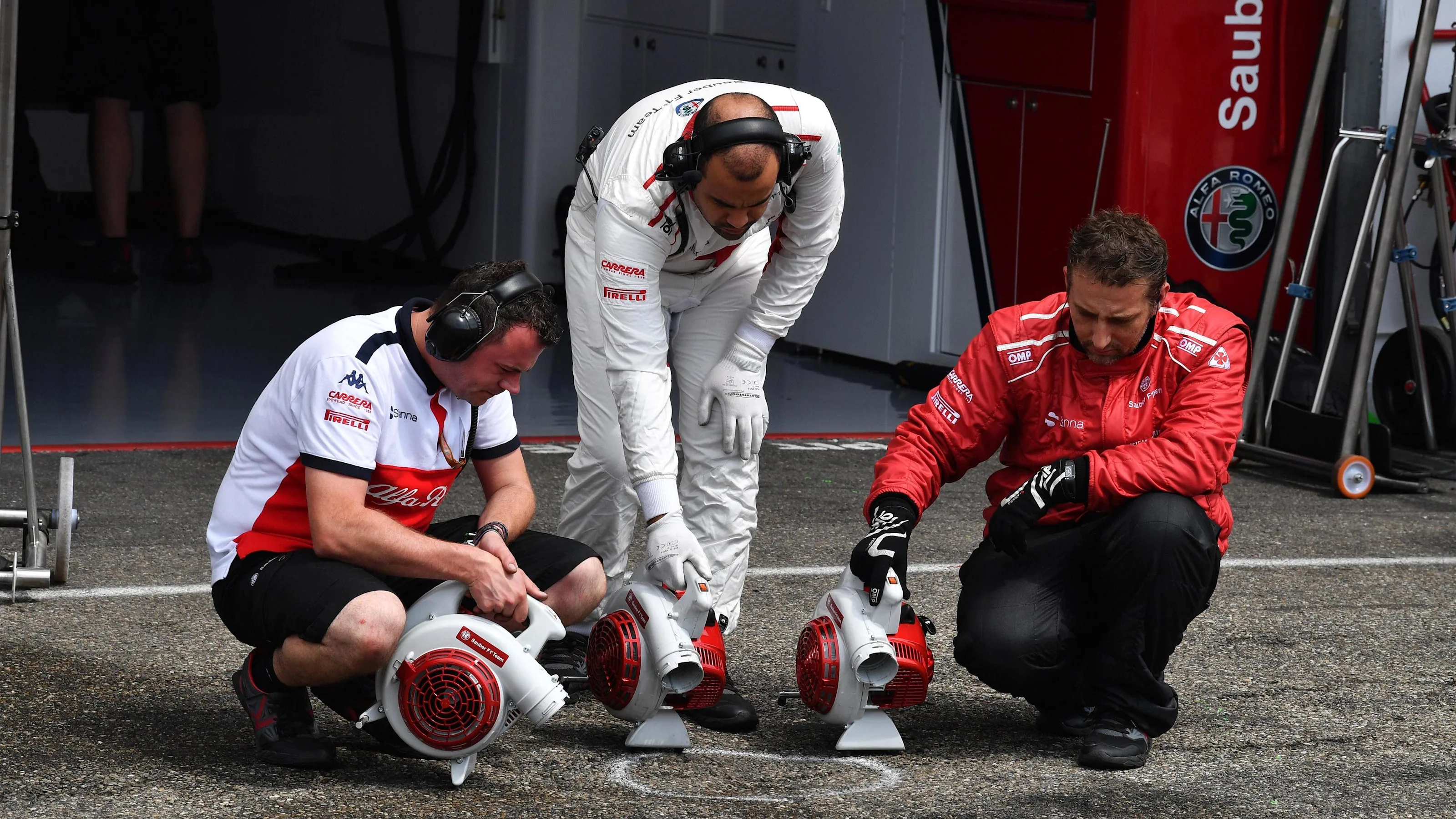Alfa Romeo Sauber F1 Team mechanics dry the pit box at Formula One World Championship, Rd11, German