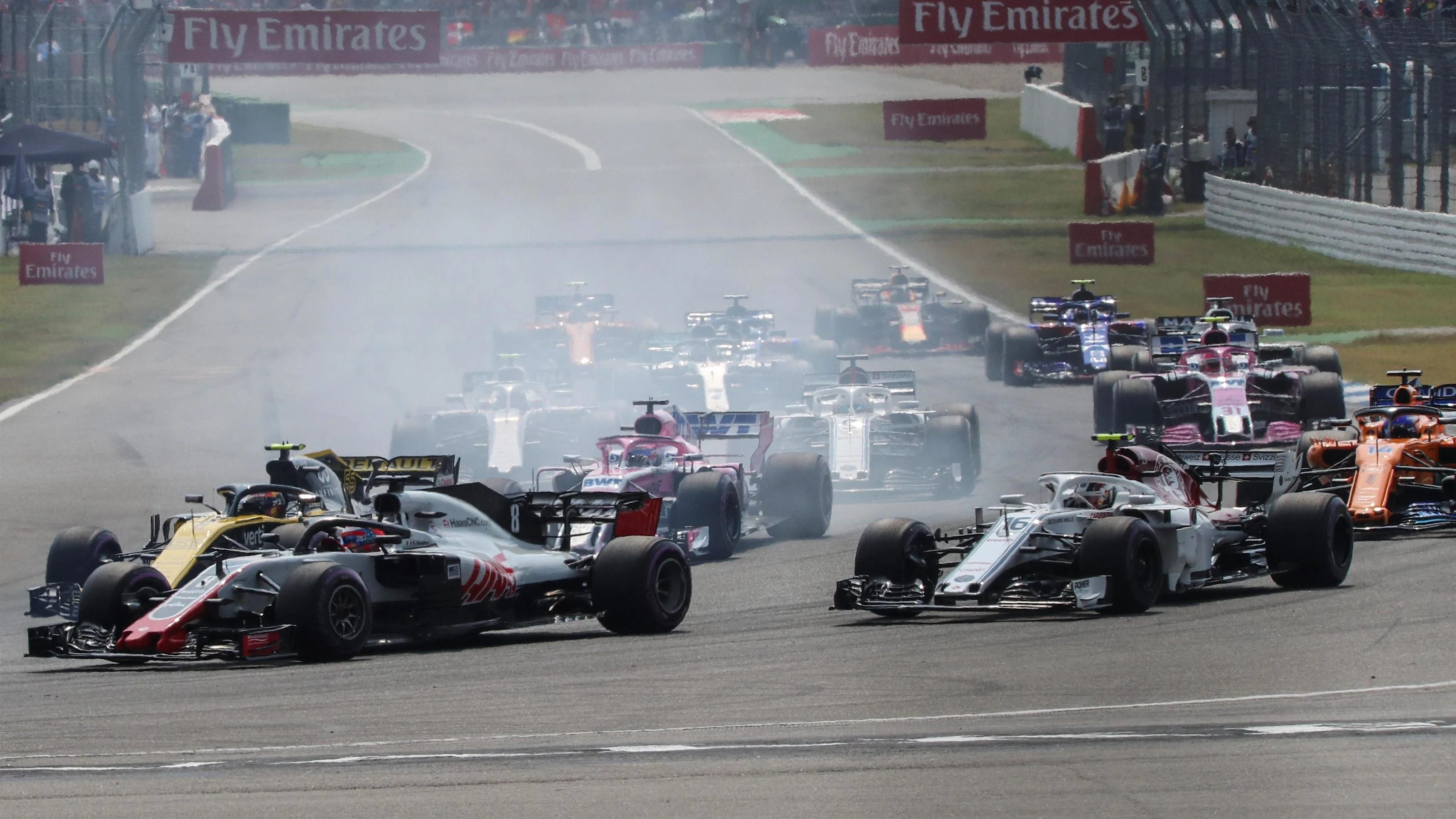Romain Grosjean (FRA) Haas VF-18 and Carlos Sainz jr (ESP) Renault Sport F1 Team RS18 battle on lap