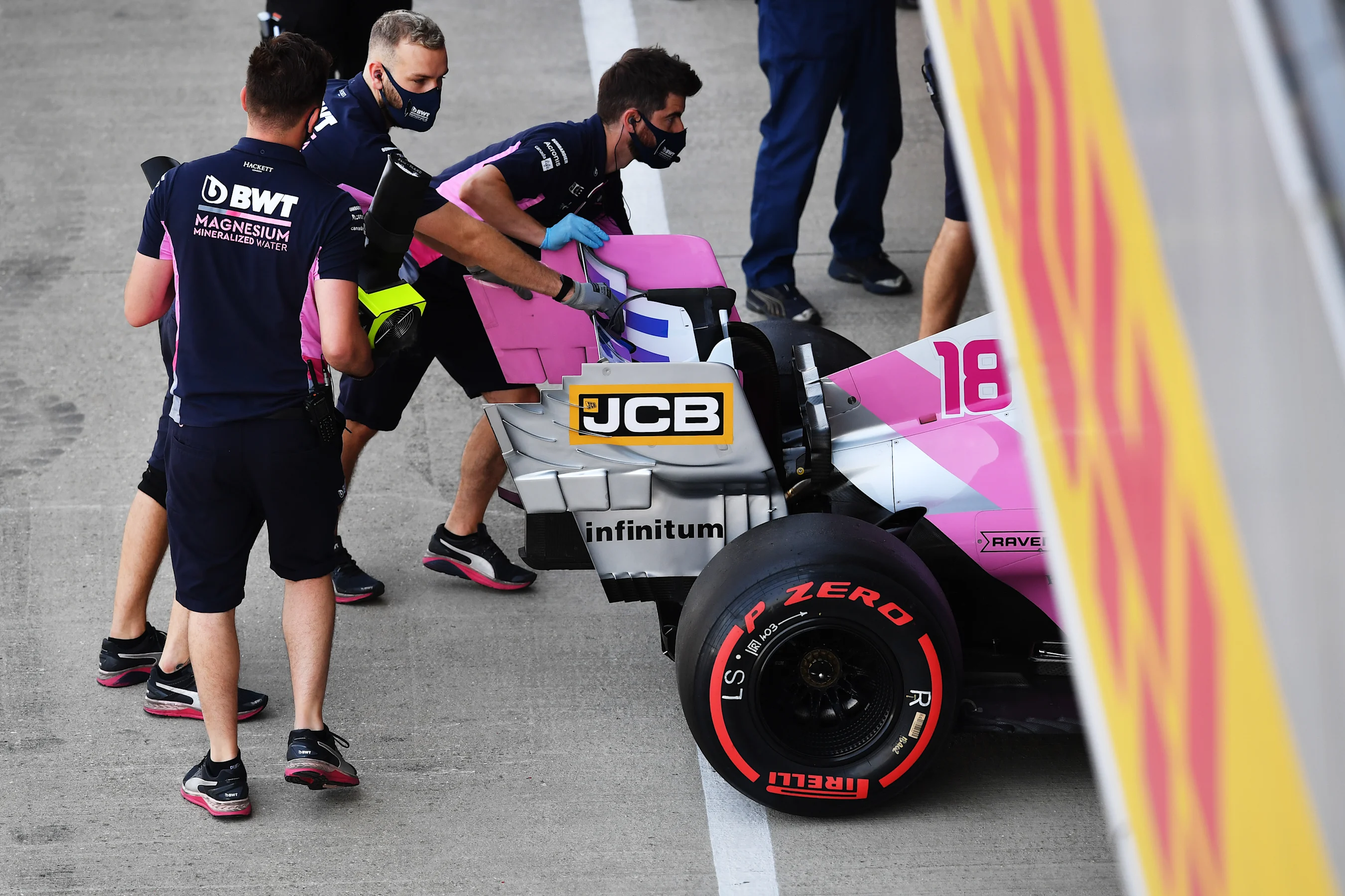NORTHAMPTON, ENGLAND - AUGUST 08: Racing Point team members push the car of Lance Stroll of Canada