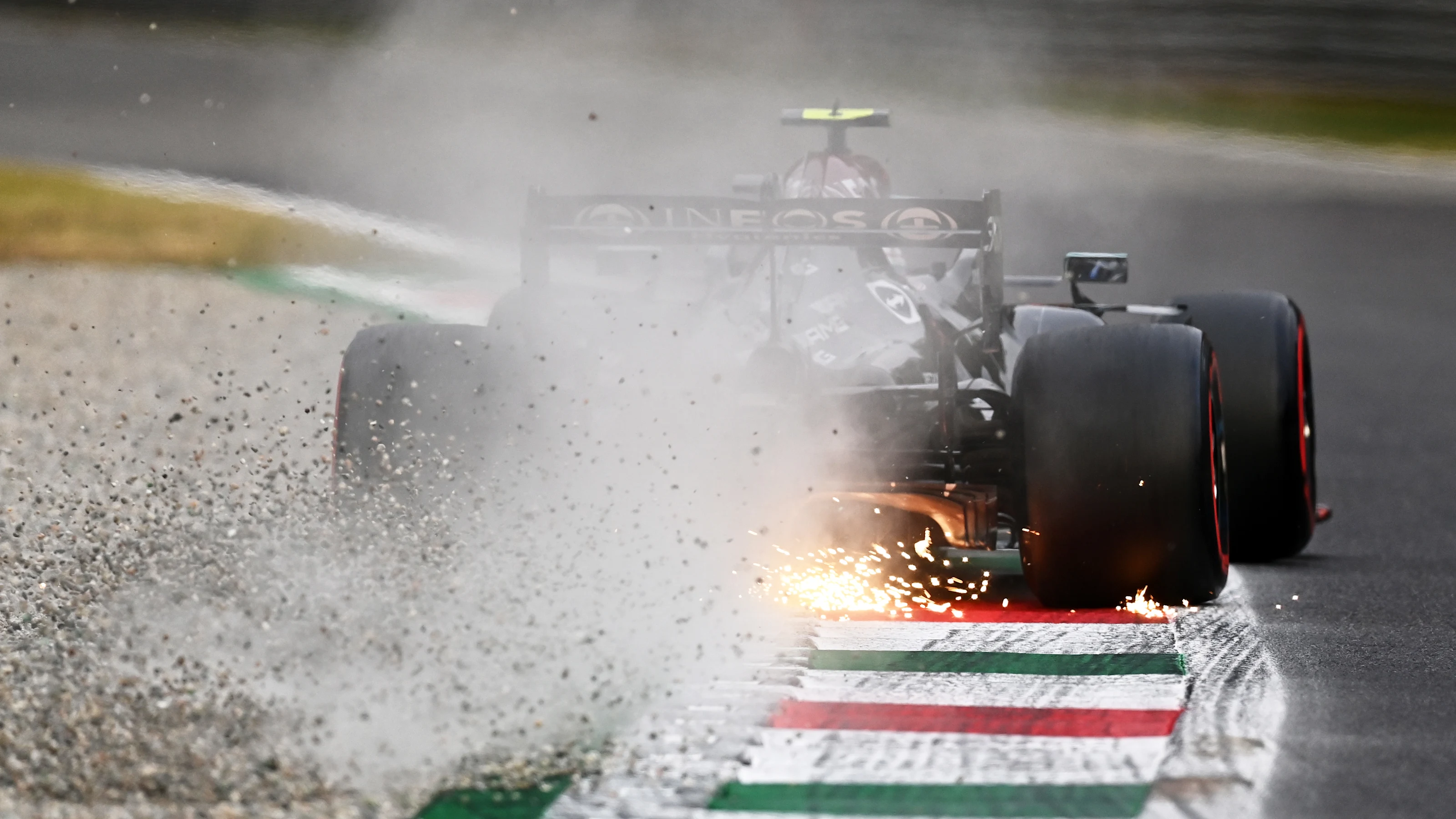 MONZA, ITALY - SEPTEMBER 10: Sparks and gravel fly behind Valtteri Bottas of Finland driving the