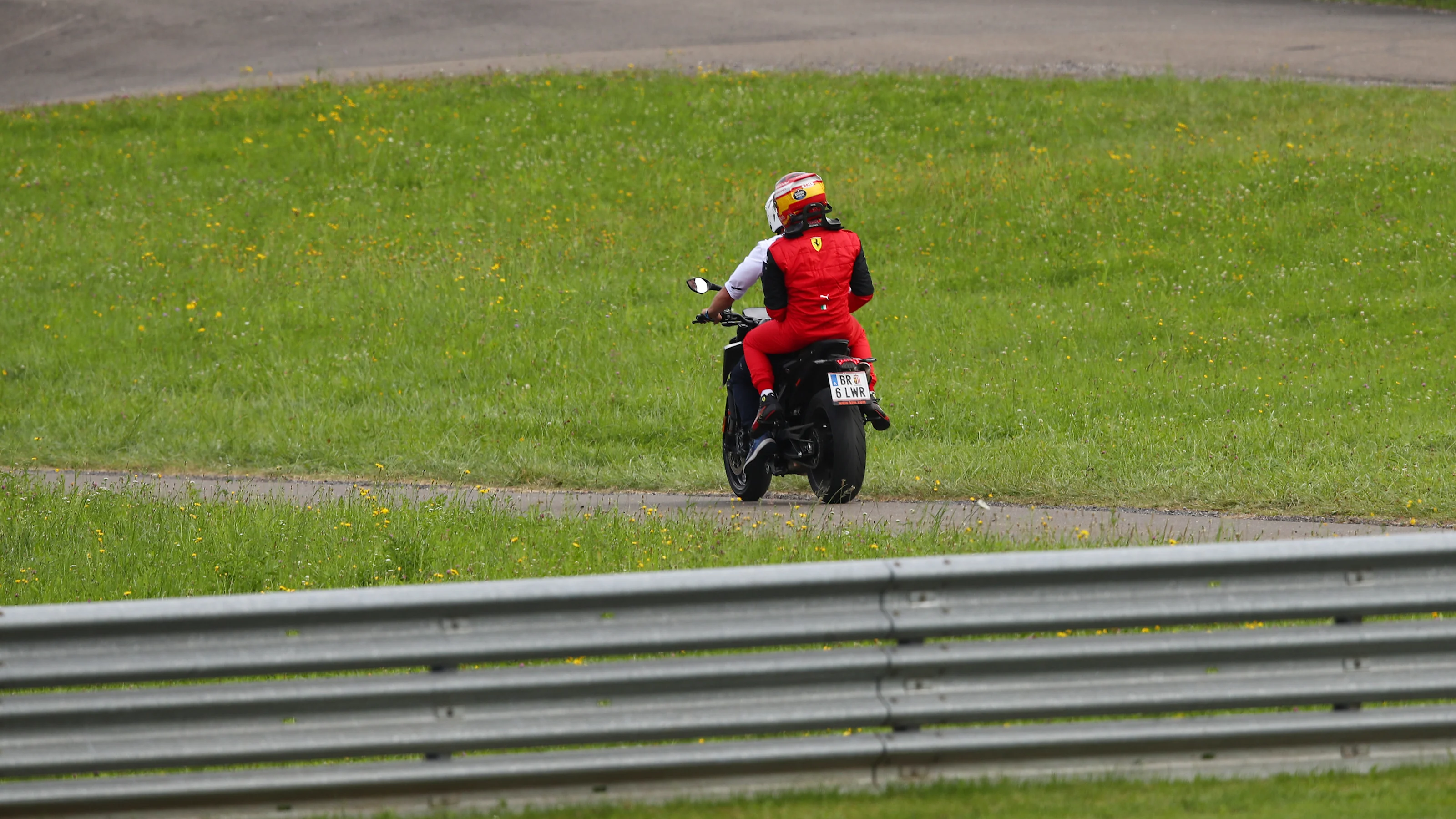 SPIELBERG, AUSTRIA - JULY 10: Carlos Sainz of Spain and Ferrari is driven back to the paddock after