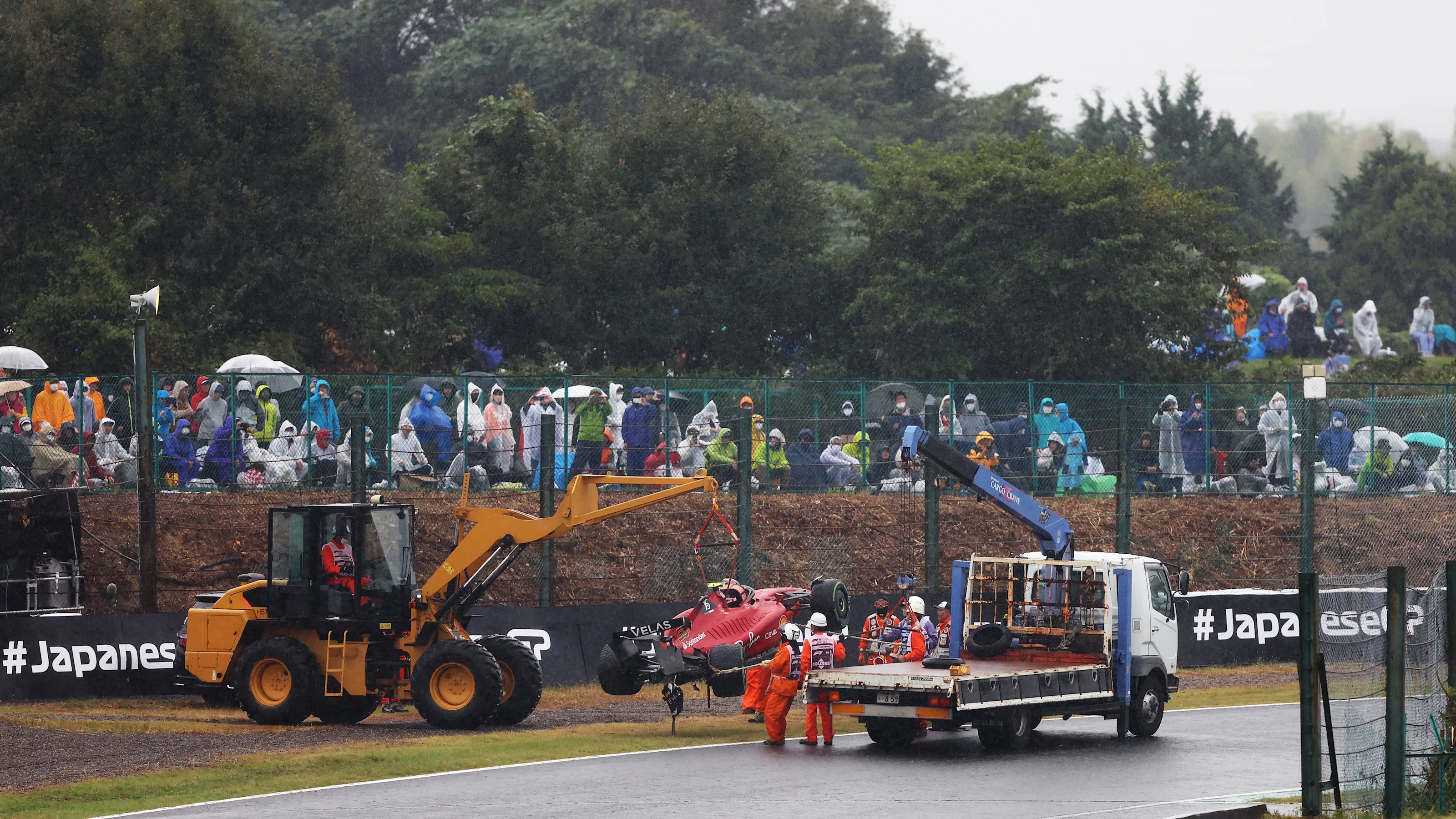 SUZUKA, JAPAN - OCTOBER 09: The car of Carlos Sainz of Spain and Ferrari is recovered from the