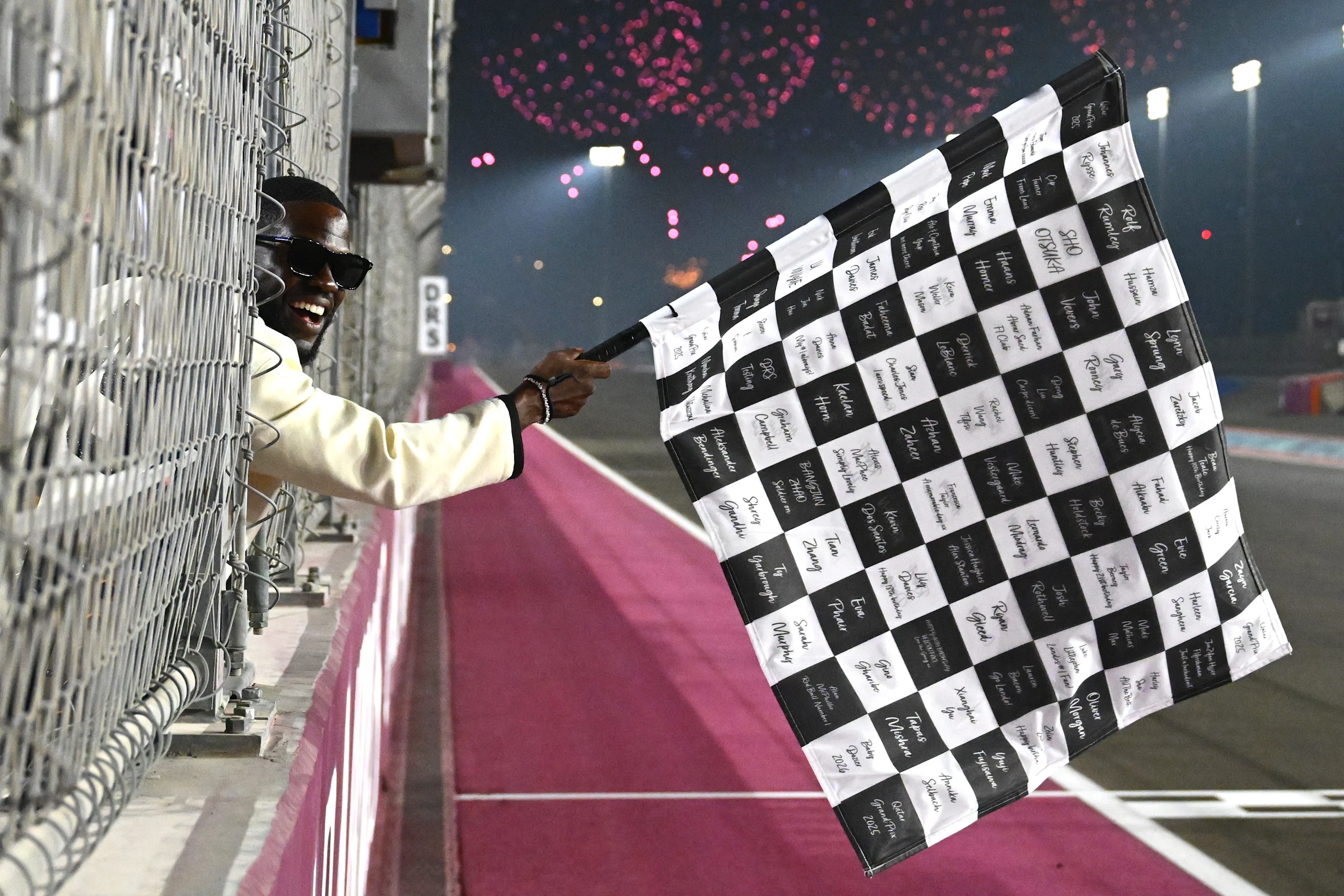 LUSAIL CITY, QATAR - NOVEMBER 30: Kevin Hart waves the chequered flag during the F1 Grand Prix of