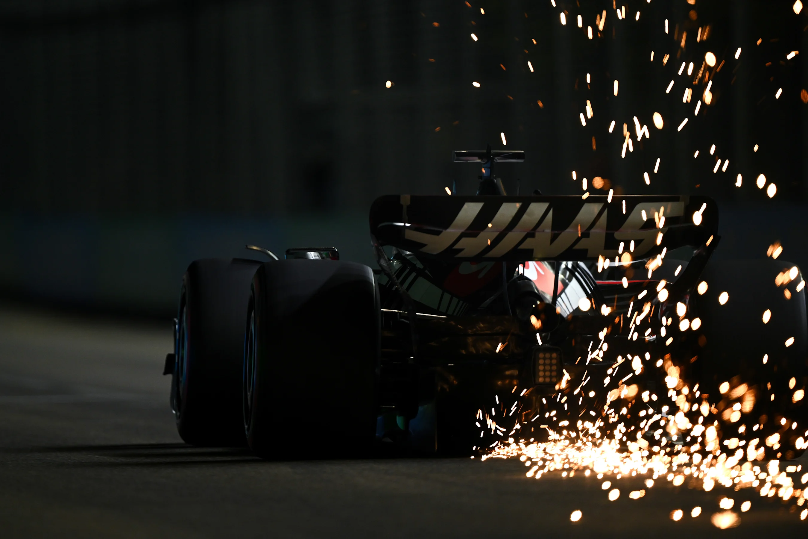 SINGAPORE, SINGAPORE - SEPTEMBER 16: Sparks fly from the car of Kevin Magnussen of Denmark driving
