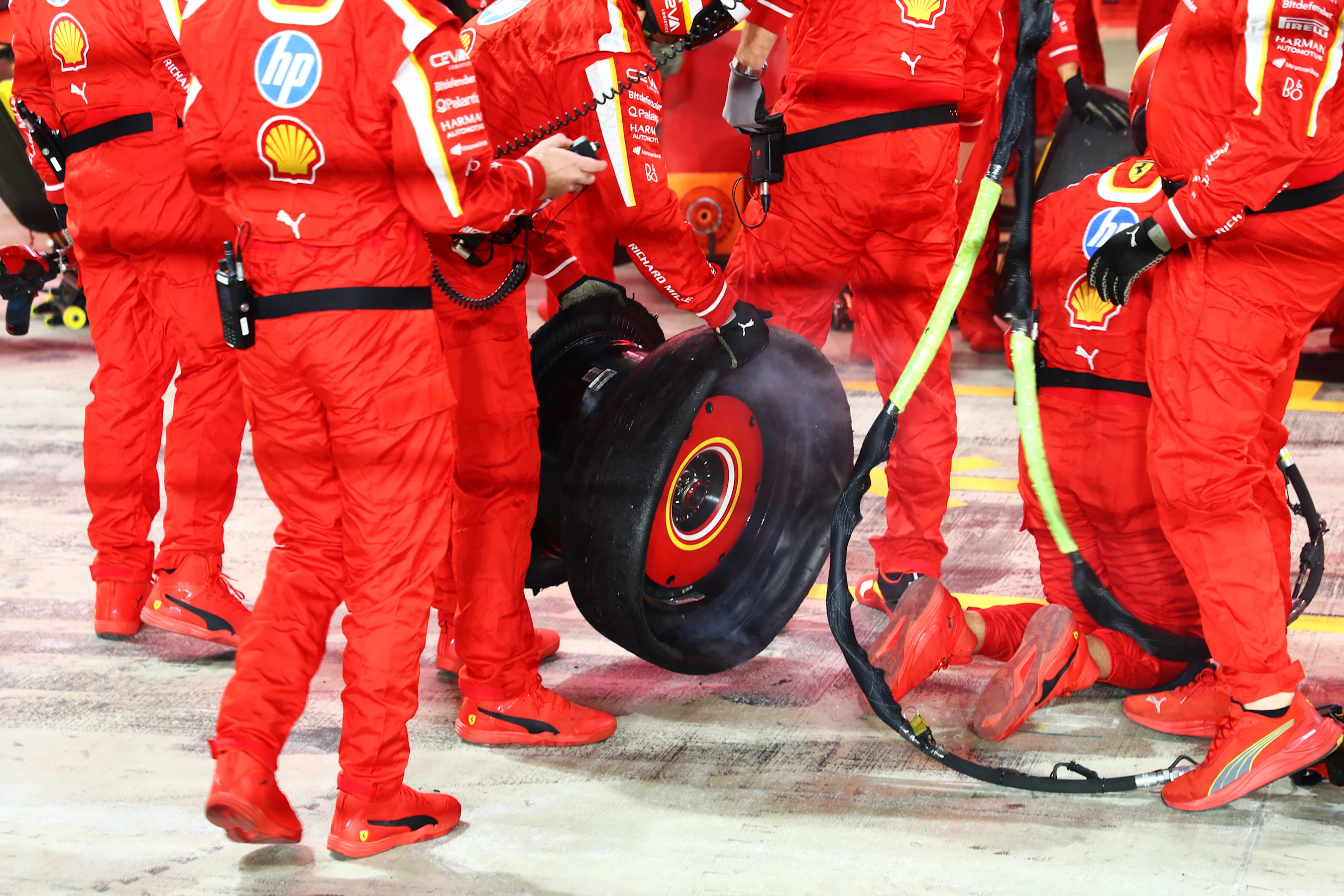 LUSAIL CITY, QATAR - DECEMBER 01: Ferrari team members hold the punctured tire of Carlos Sainz of