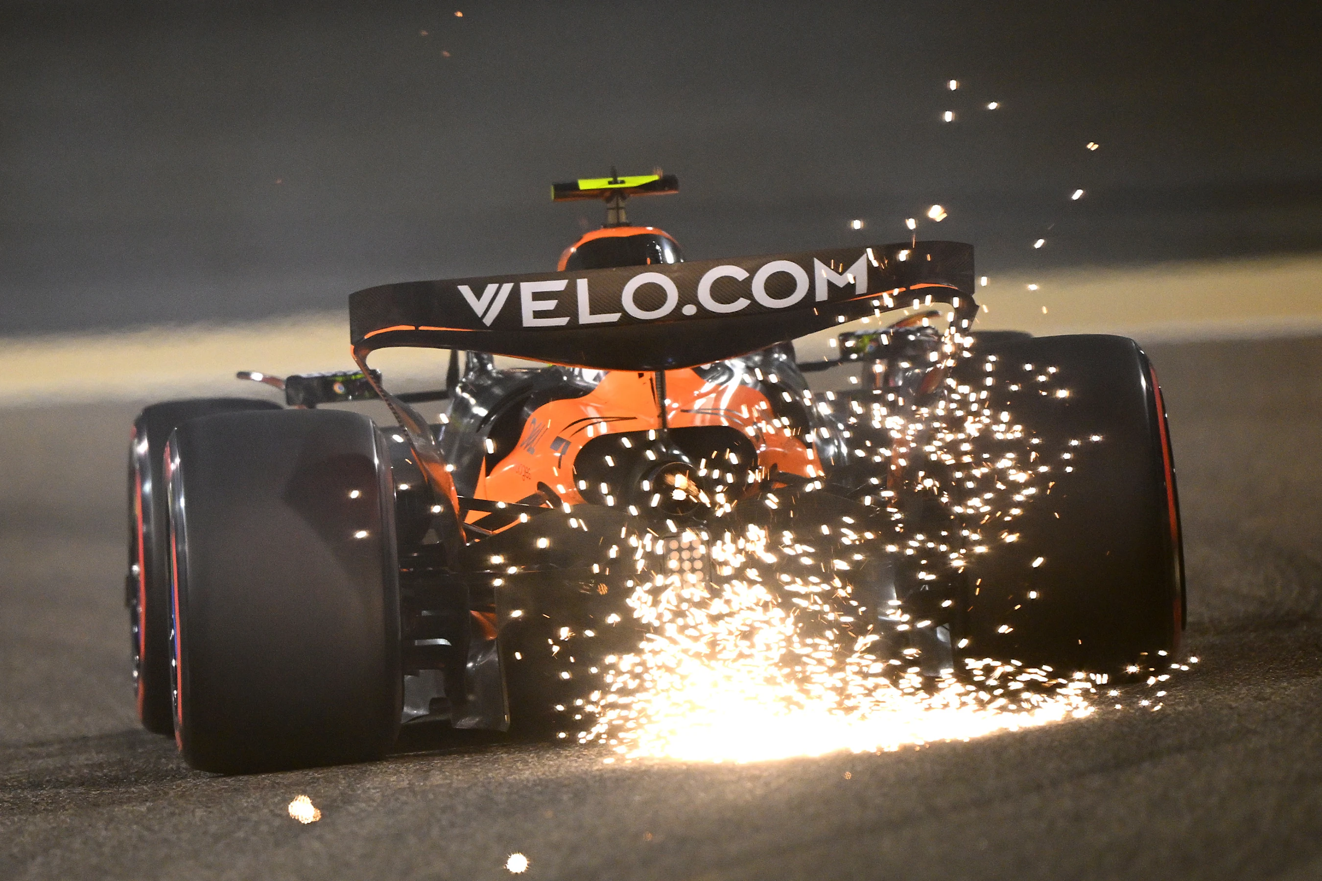 BAHRAIN, BAHRAIN - APRIL 11: Sparks fly behind Lando Norris of Great Britain driving the (4)