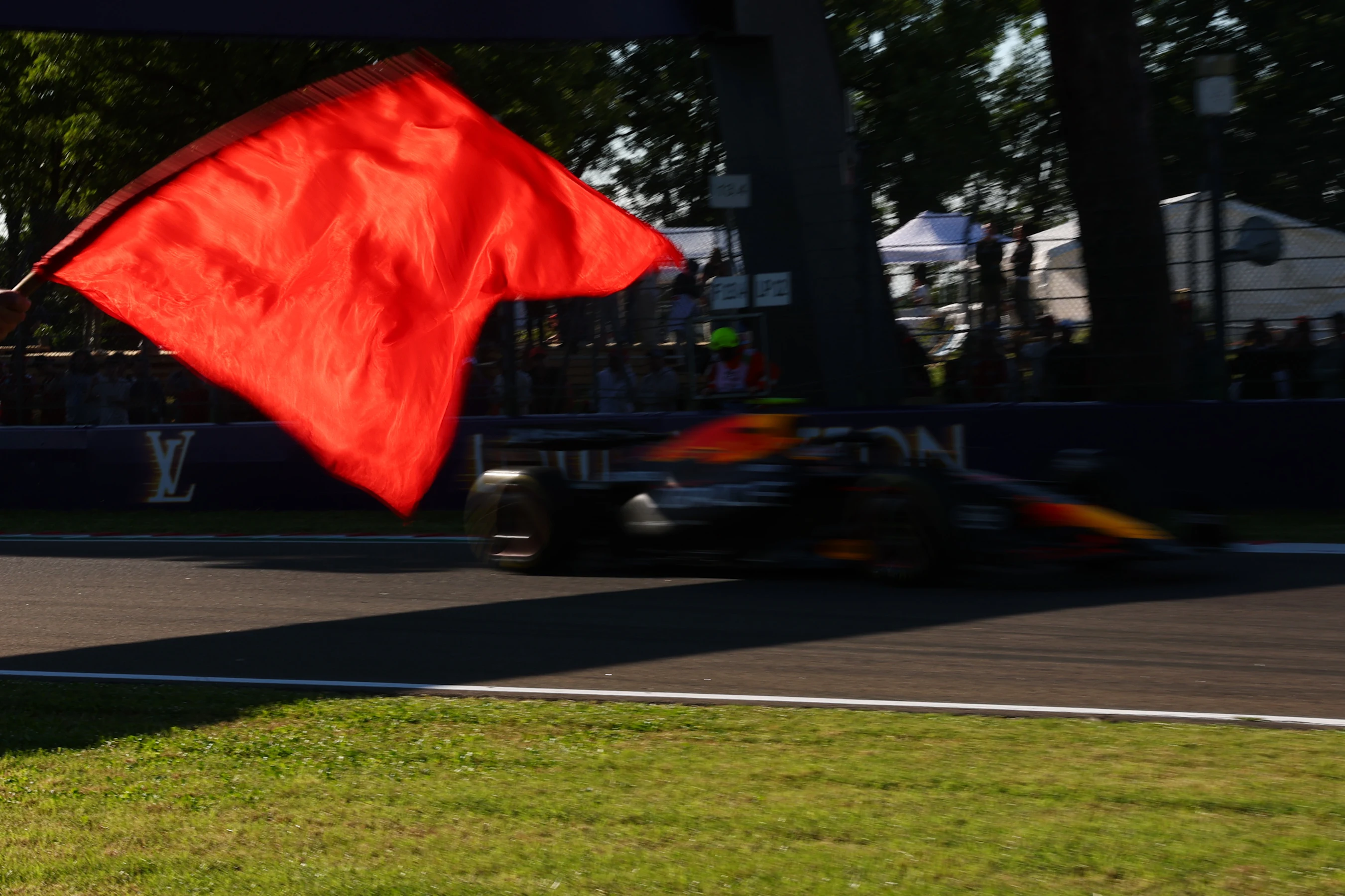 IMOLA, ITALY - MAY 16: A marshal waves a red flag as Yuki Tsunoda of Japan driving the (22) Oracle