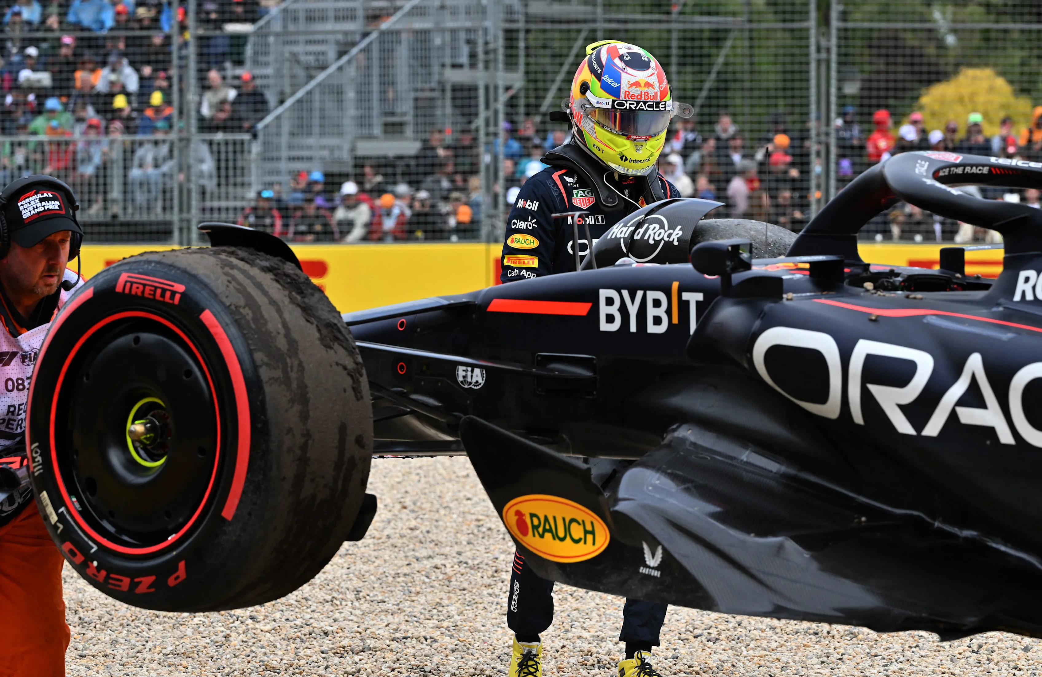 Red Bull Racing's Mexican driver Sergio Perez looks on as marshals remove his car from the side of