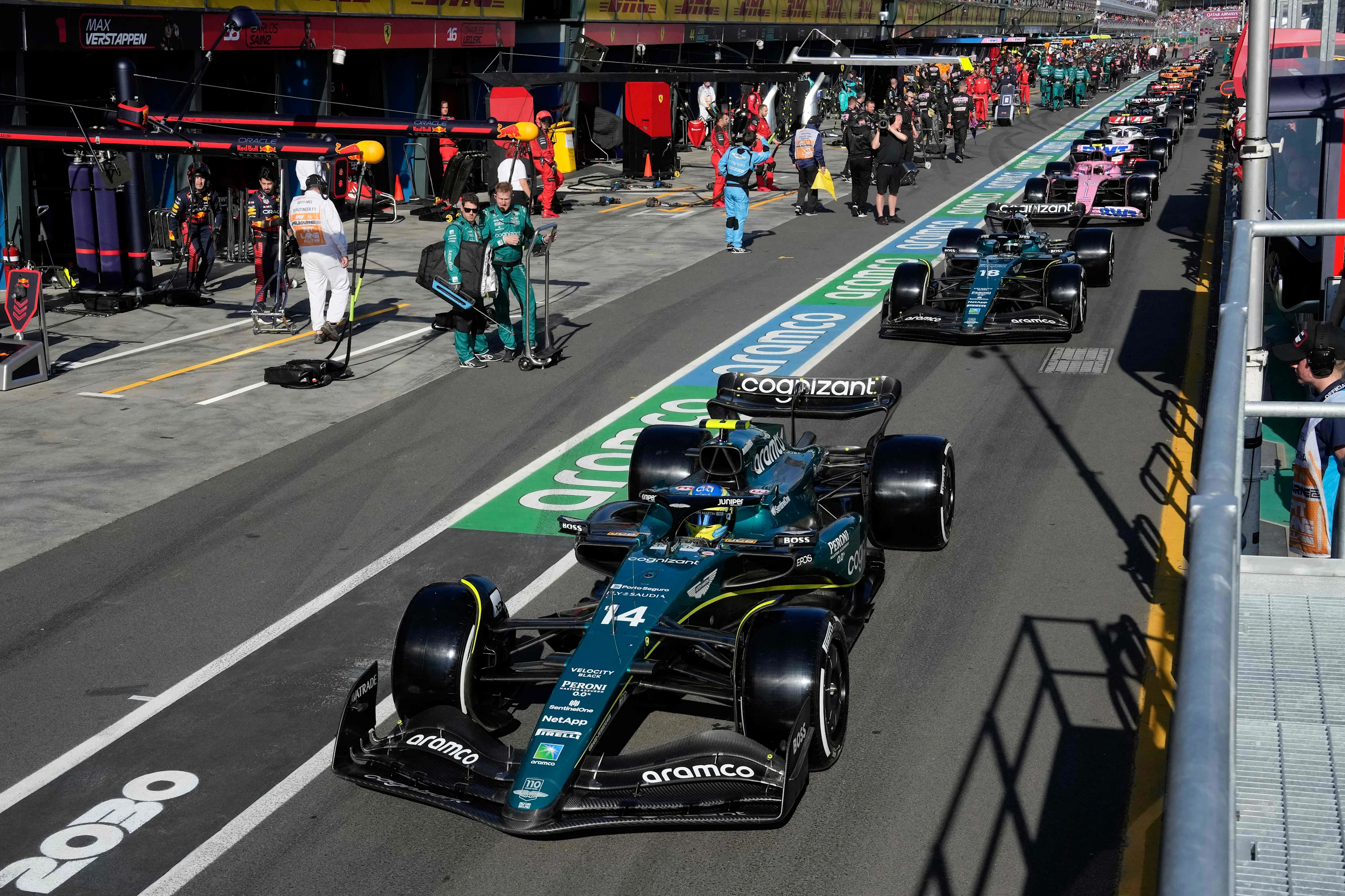 Aston Martin's Spanish driver Fernando Alonso and other drivers line up in the pit lane during a