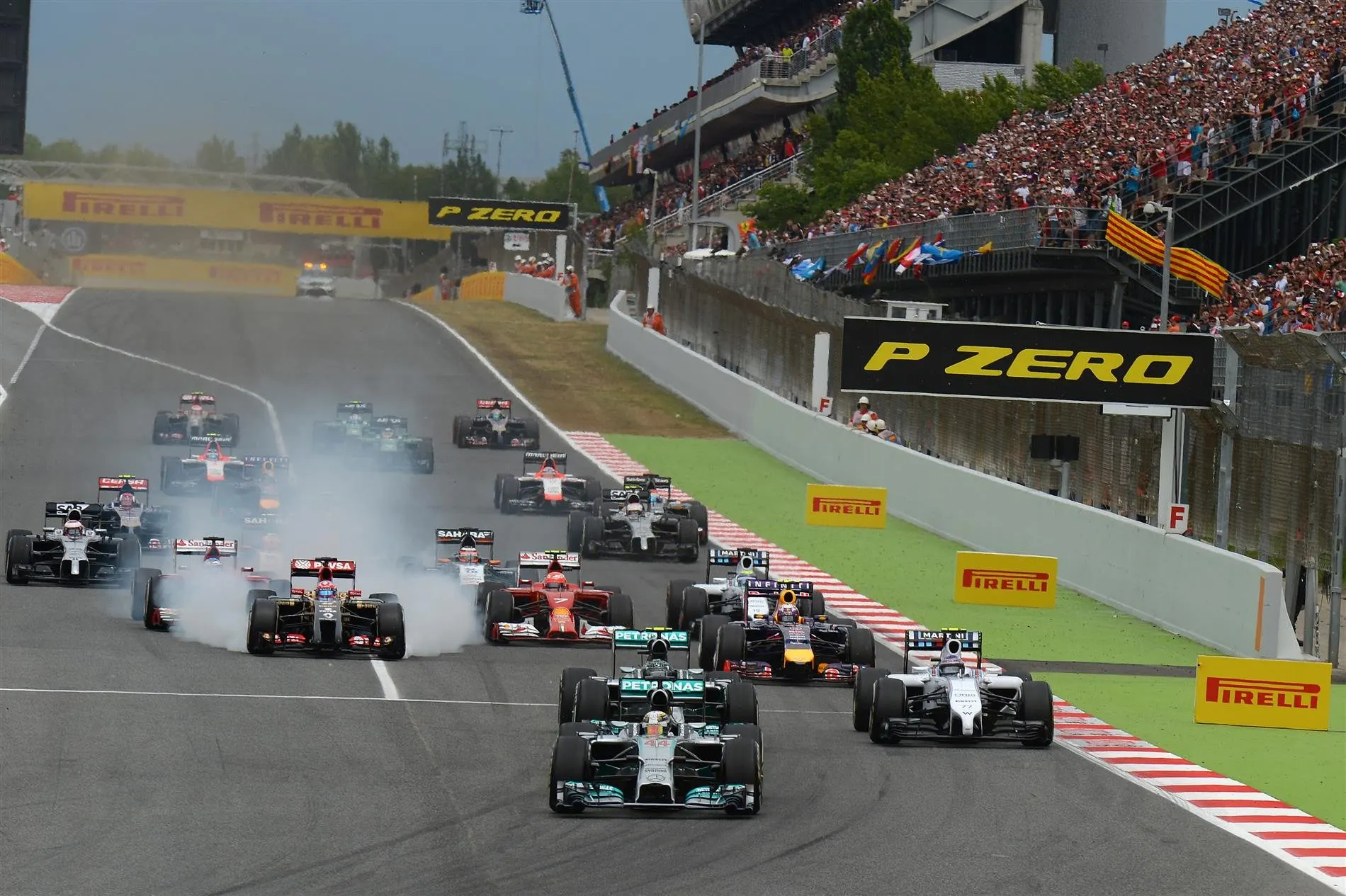 Lewis Hamilton (GBR) Mercedes AMG F1 W05 leads at the start of the race as Romain Grosjean (FRA) Lotus E22 locks up his brakes. Formula One World Championship, Rd5, Spanish Grand Prix, Race, Barcelona, Spain, Sunday, 11 May 2014. © Sutton Images