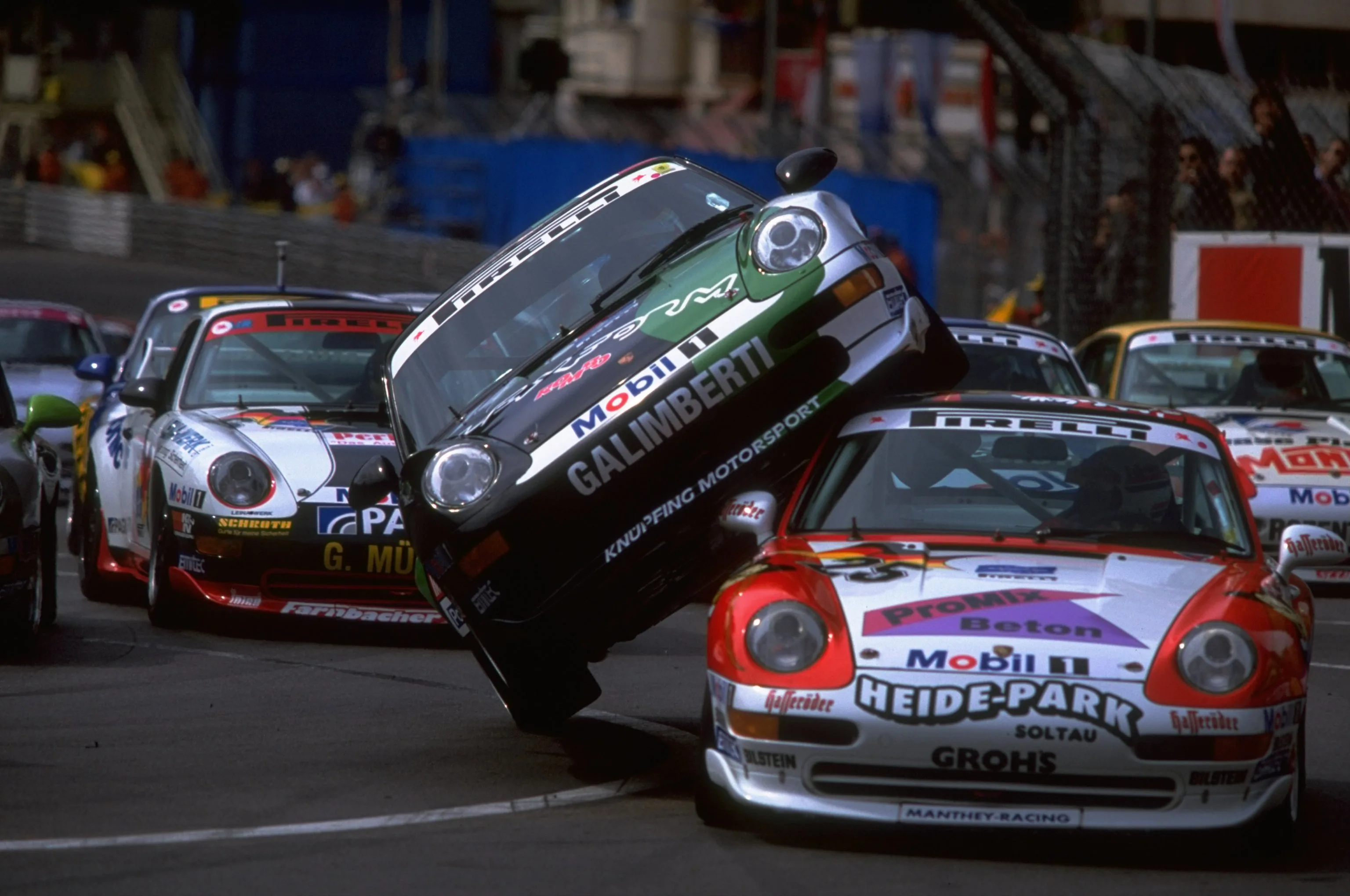 11 May 1997: Matteo Maria Galimberti (centre) monts Harald Grohs on the first lap of the Porsche