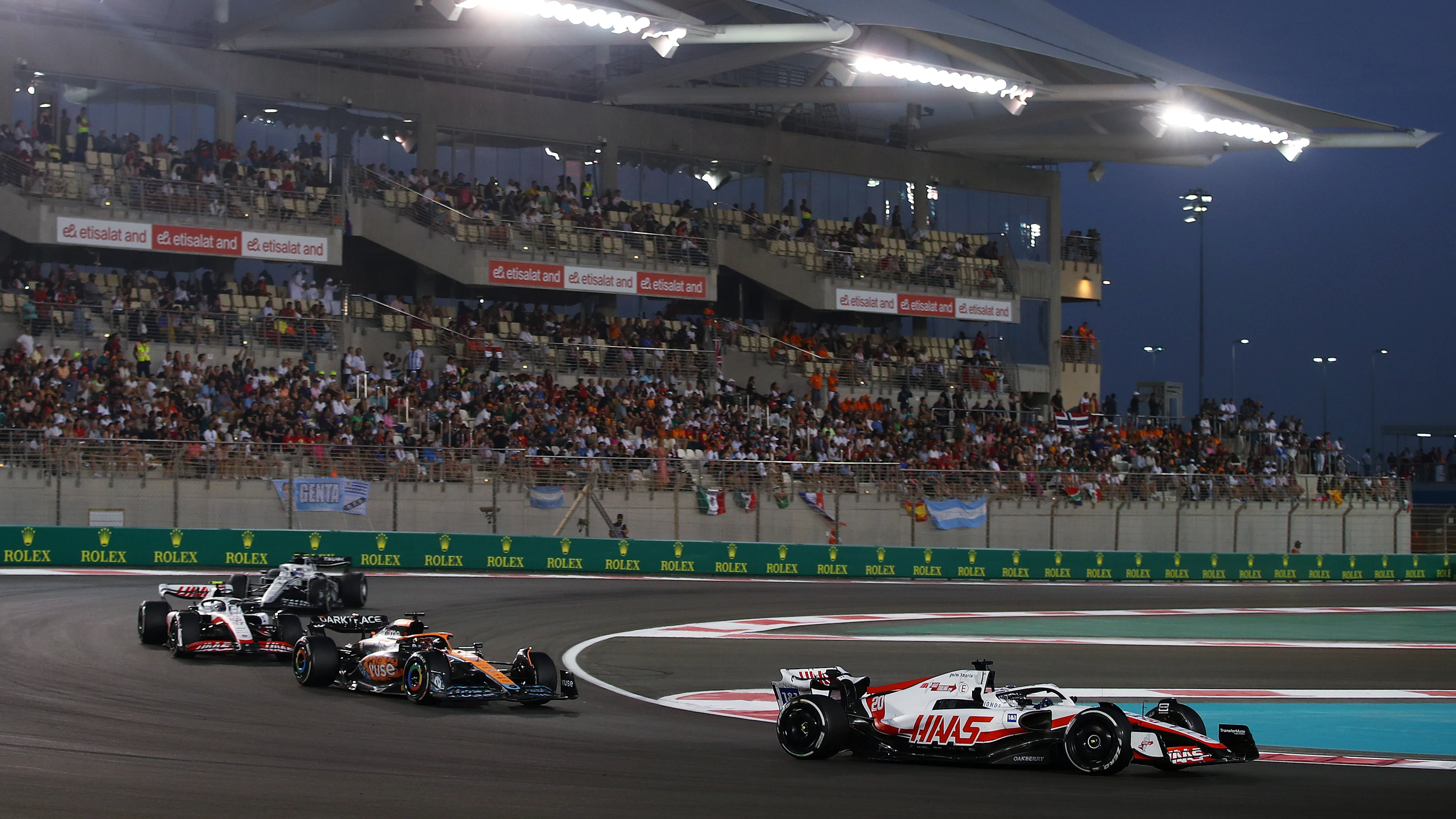 ABU DHABI, UNITED ARAB EMIRATES - NOVEMBER 20: Kevin Magnussen of Denmark driving the (20) Haas F1 VF-22 Ferrari leads Daniel Ricciardo of Australia driving the (3) McLaren MCL36 Mercedes and Mick Schumacher of Germany driving the (47) Haas F1 VF-22 Ferrari on track during the F1 Grand Prix of Abu Dhabi at Yas Marina Circuit on November 20, 2022 in Abu Dhabi, United Arab Emirates. (Photo by Joe Portlock - Formula 1/Formula 1 via Getty Images)