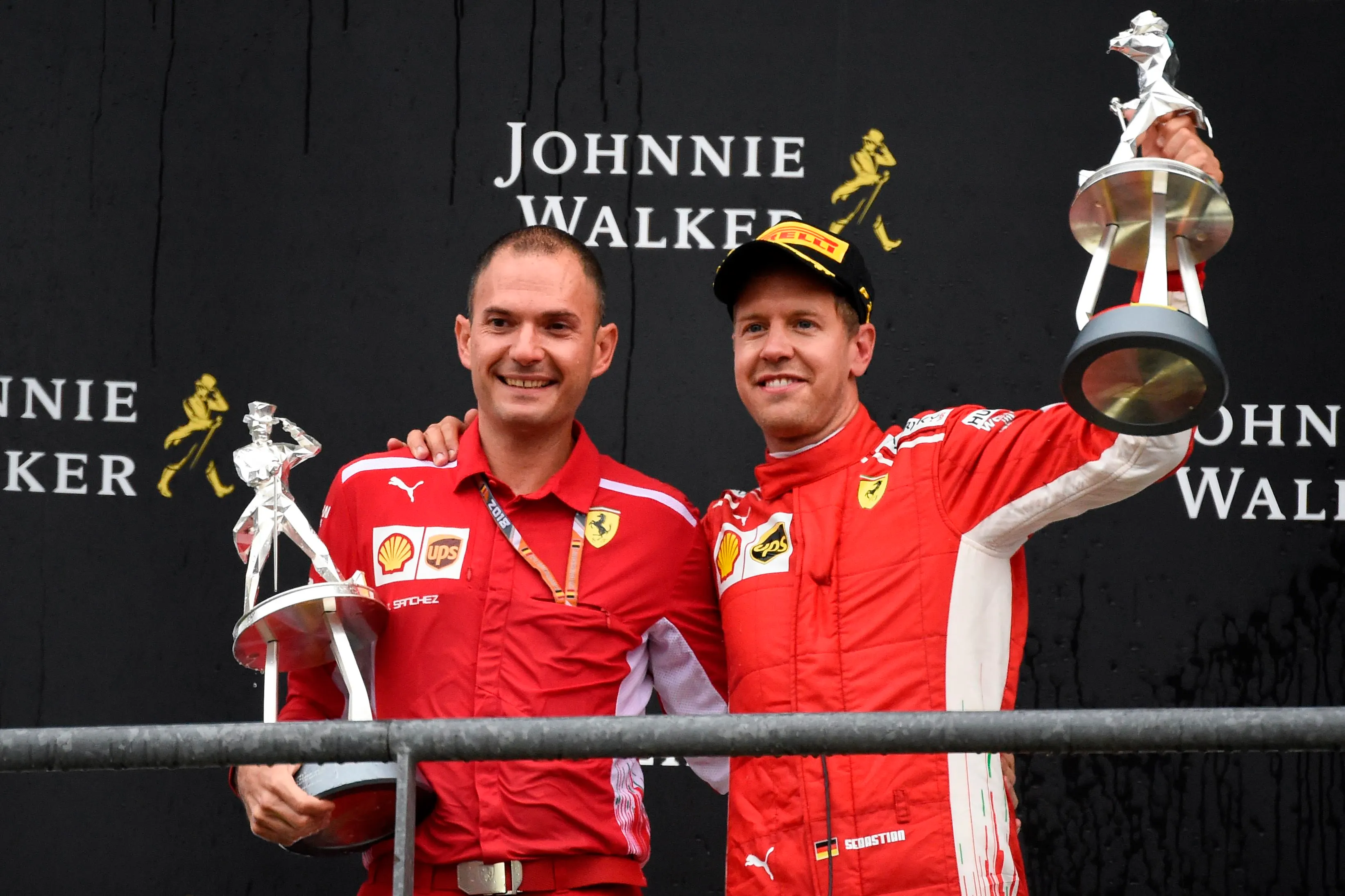 Winner Ferrari's German driver Sebastian Vettel (R) celebrates on the podium with Ferrari