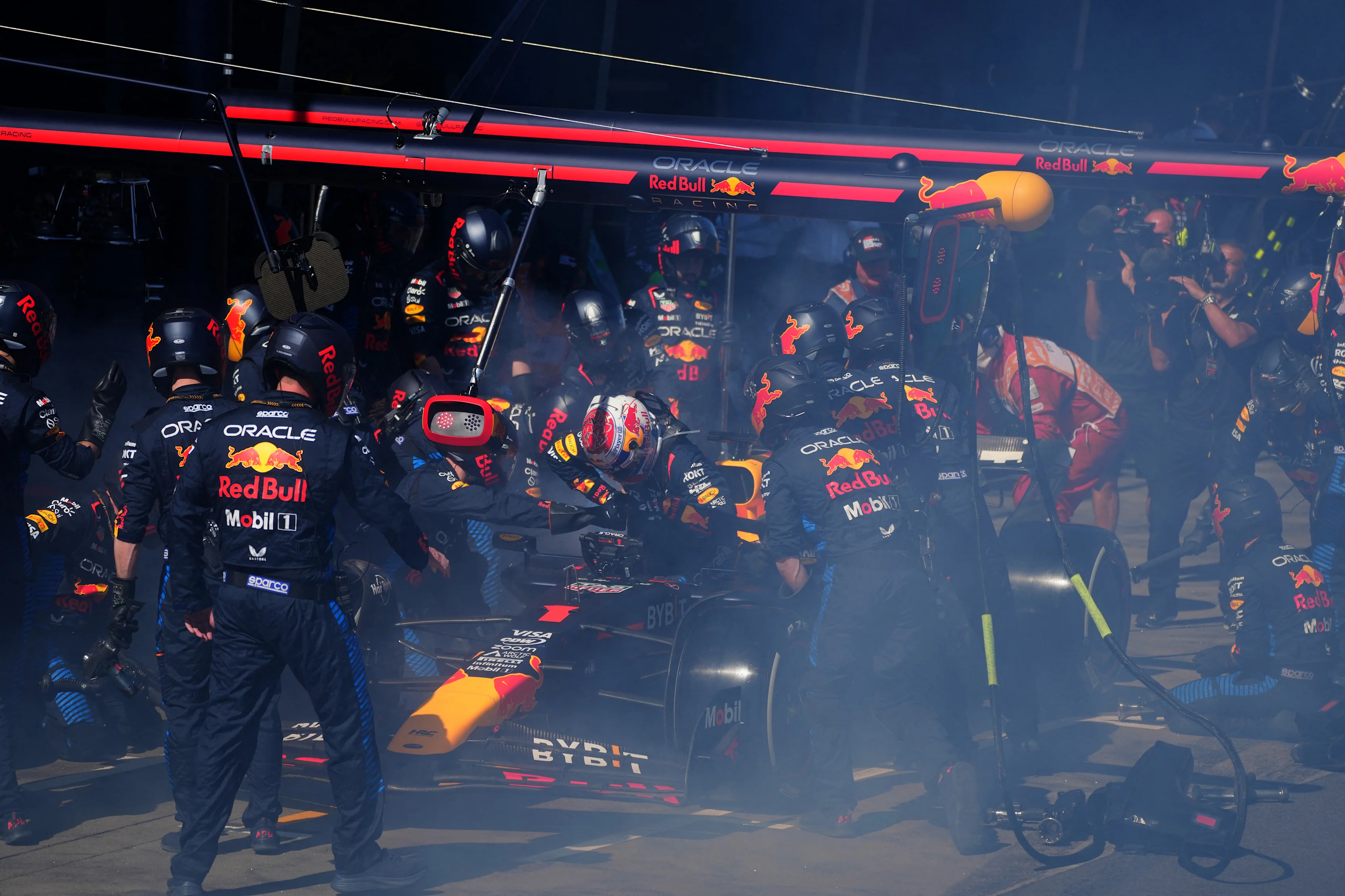 Red Bull Racing's Dutch driver Max Verstappen (C) comes out after smoke billowing from his car