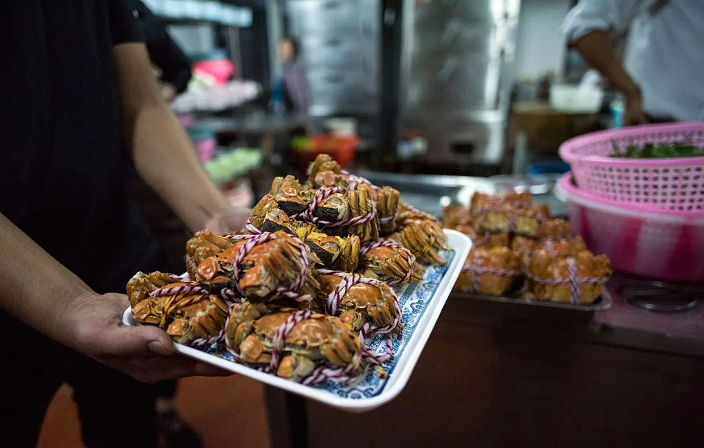 This picture taken on October 18, 2016 shows a chef holding a hairy crab dish in a restaurant in