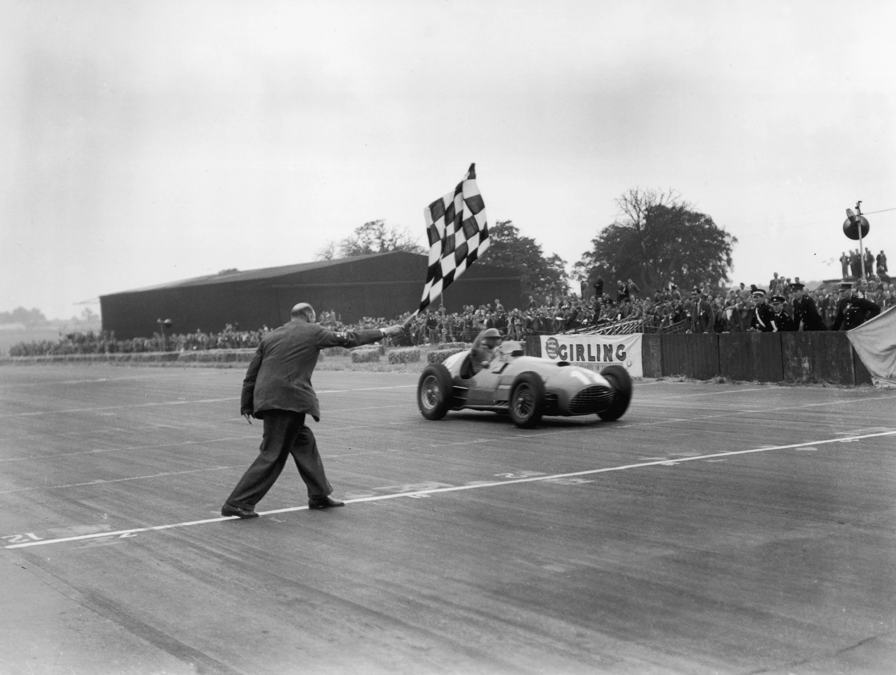 14th July 1951: Froilan Gonzalez takes the winning flag in his Ferrari 375 at the British Grand