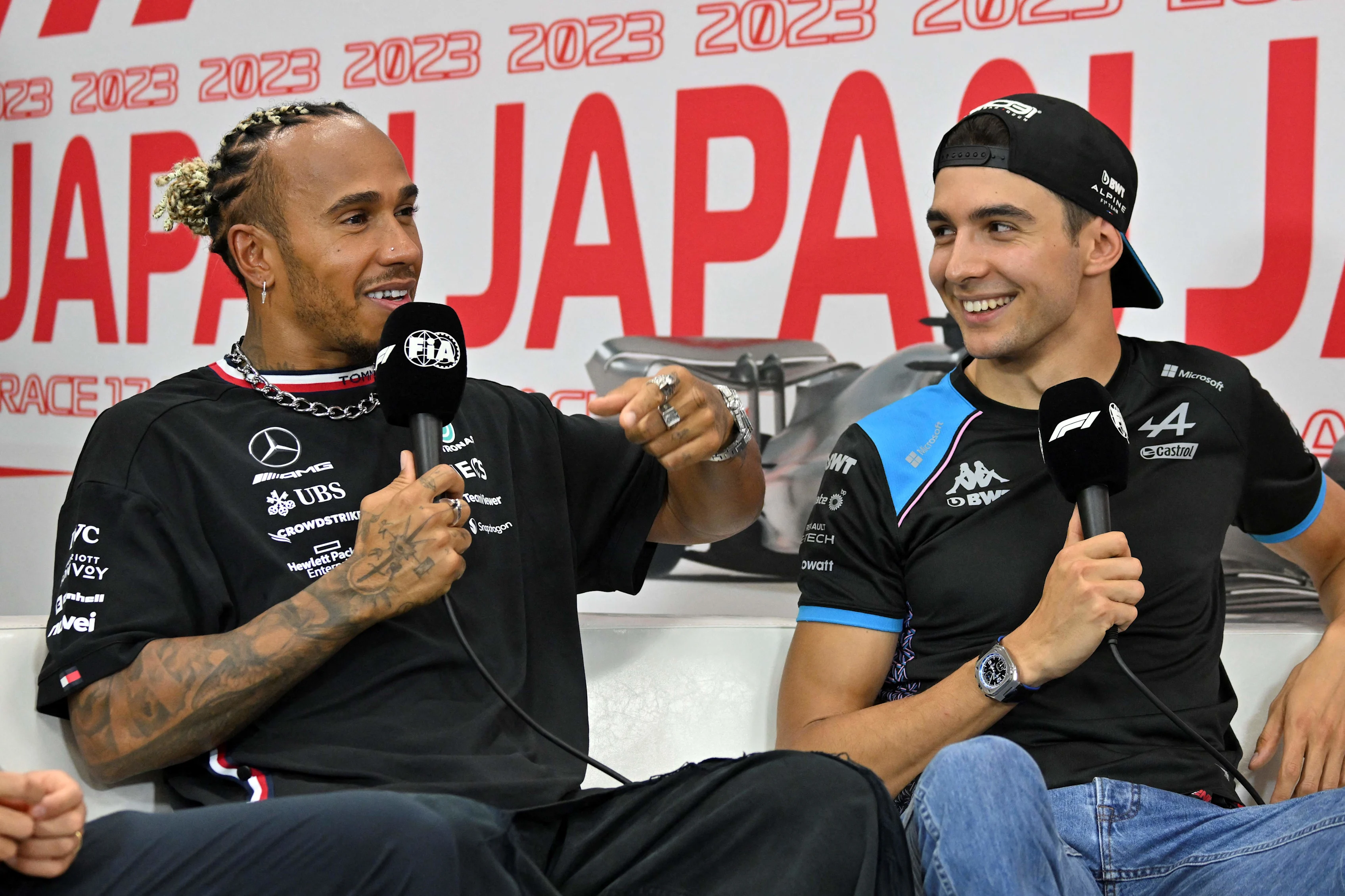 Mercedes' British driver Lewis Hamilton (L) speaks next to Alpine's French driver Esteban Ocon (R)