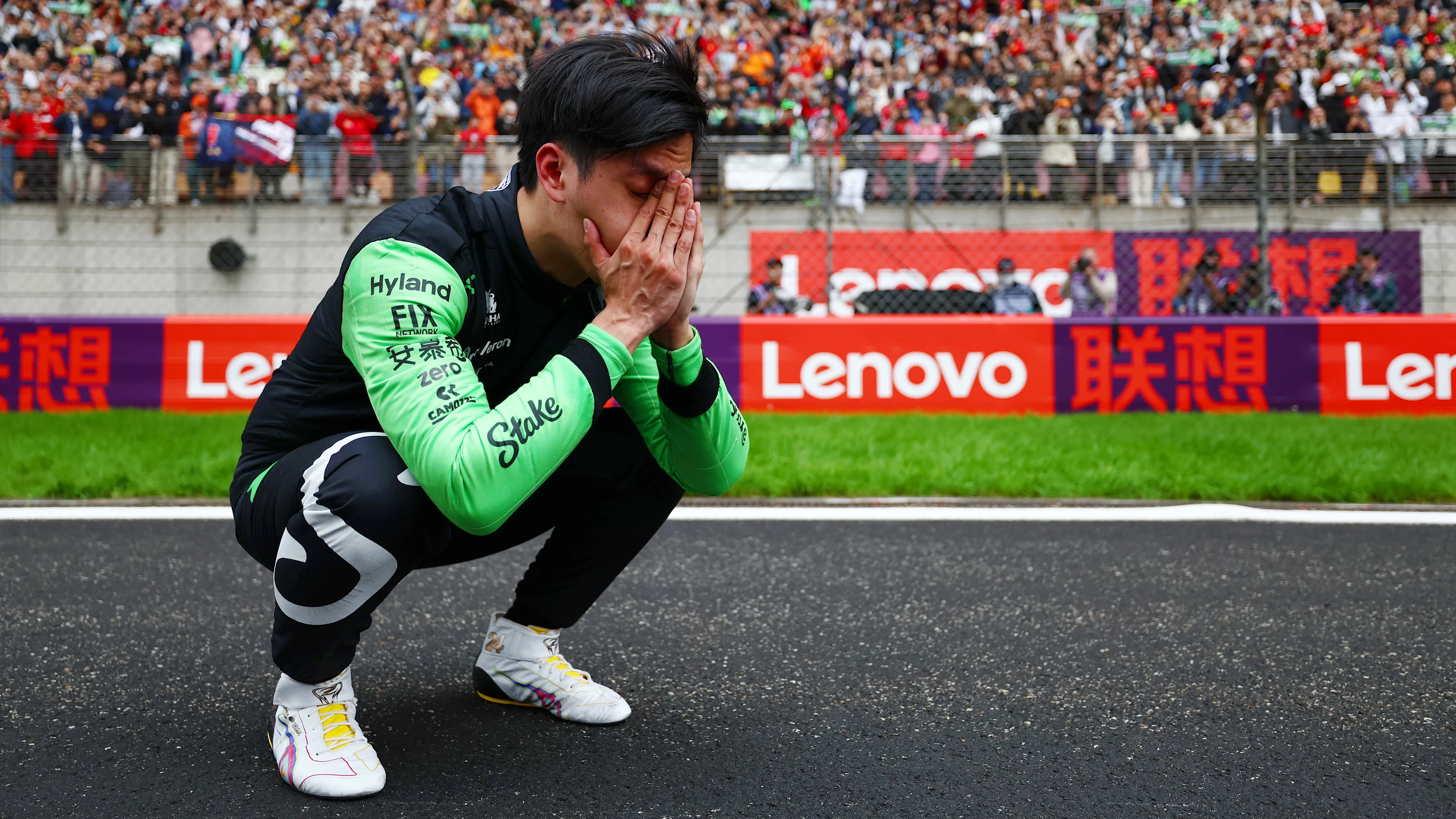21 April 2024: Guanyu Zhou of Kick Sauber with his head in his hands crouching on the main straight at the Chinese Grand Prix