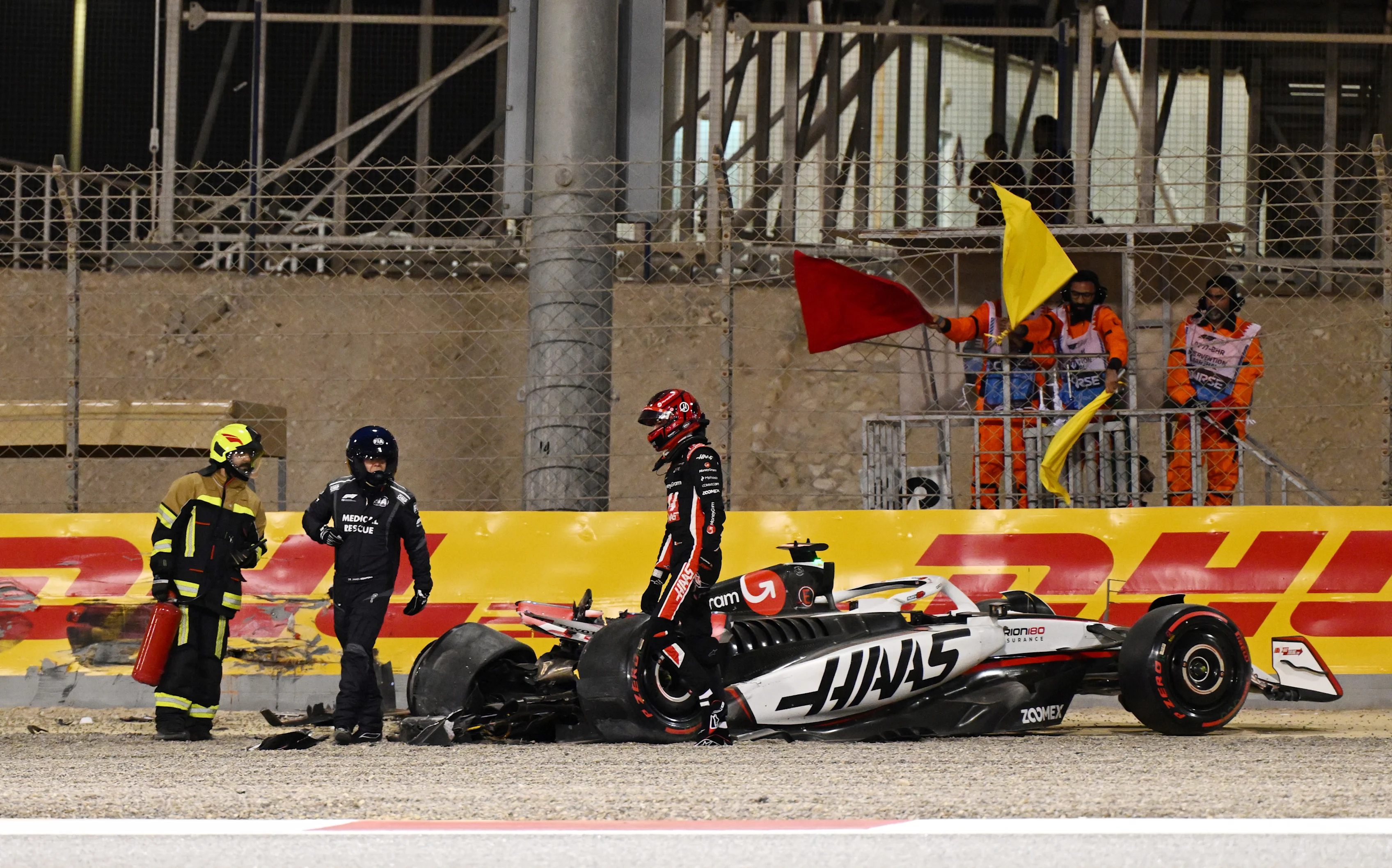 BAHRAIN, BAHRAIN - APRIL 12: Marshals assist Esteban Ocon of France and Haas F1 after a crash