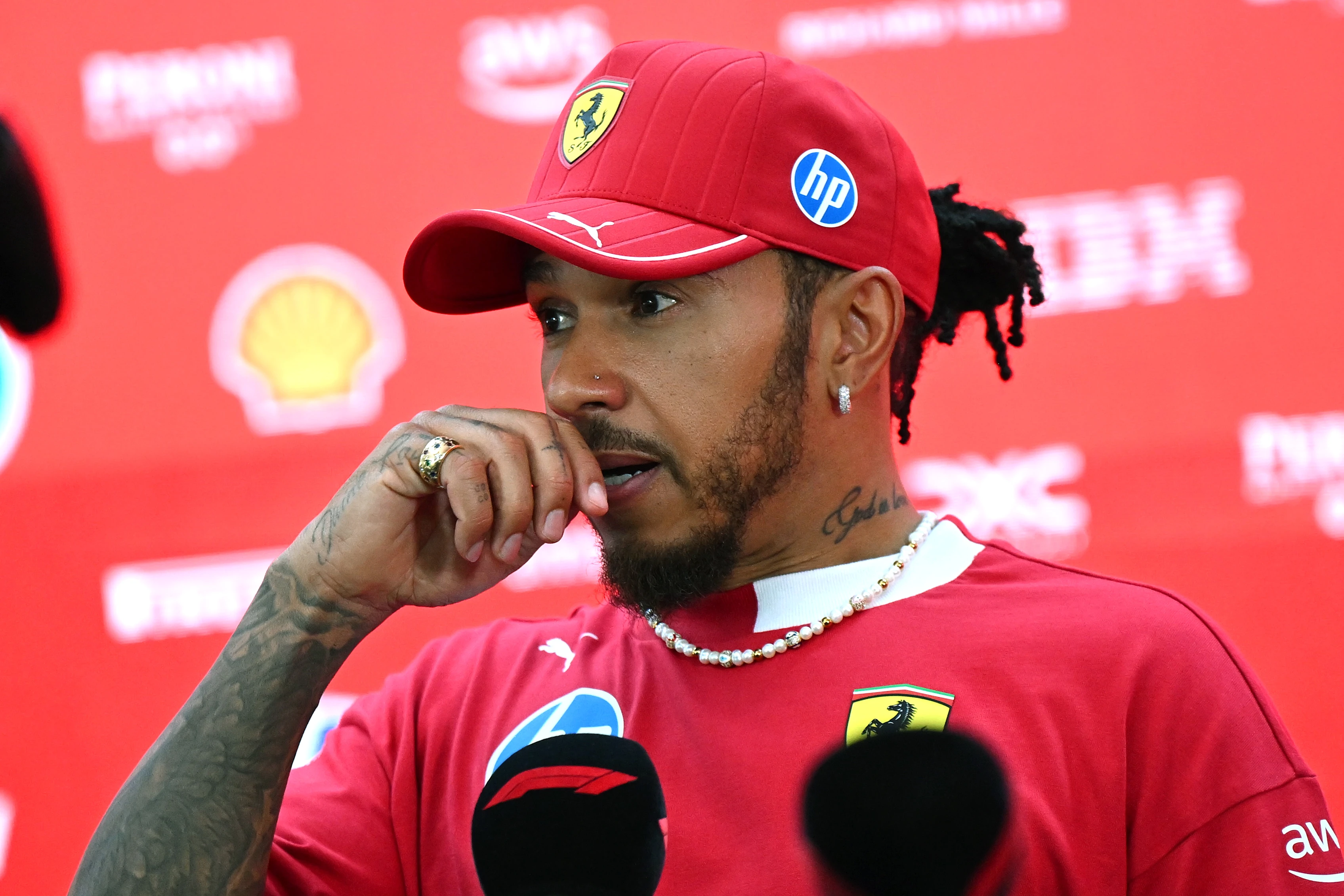 SINGAPORE, SINGAPORE - OCTOBER 02: Lewis Hamilton of Great Britain and Scuderia Ferrari talks to