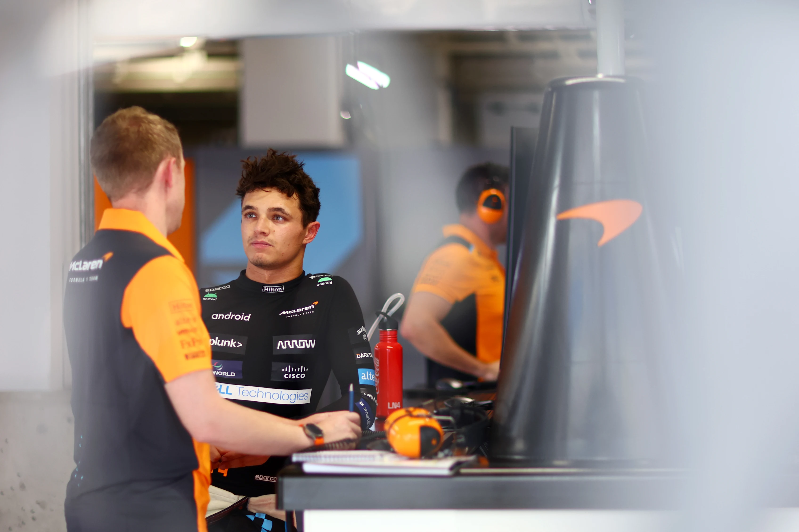 SUZUKA, JAPAN - SEPTEMBER 22: Lando Norris of Great Britain and McLaren talks with a McLaren team member in the garage during practice ahead of the F1 Grand Prix of Japan at Suzuka International Racing Course on September 22, 2023 in Suzuka, Japan. (Photo by Dan Istitene - Formula 1/Formula 1 via Getty Images)