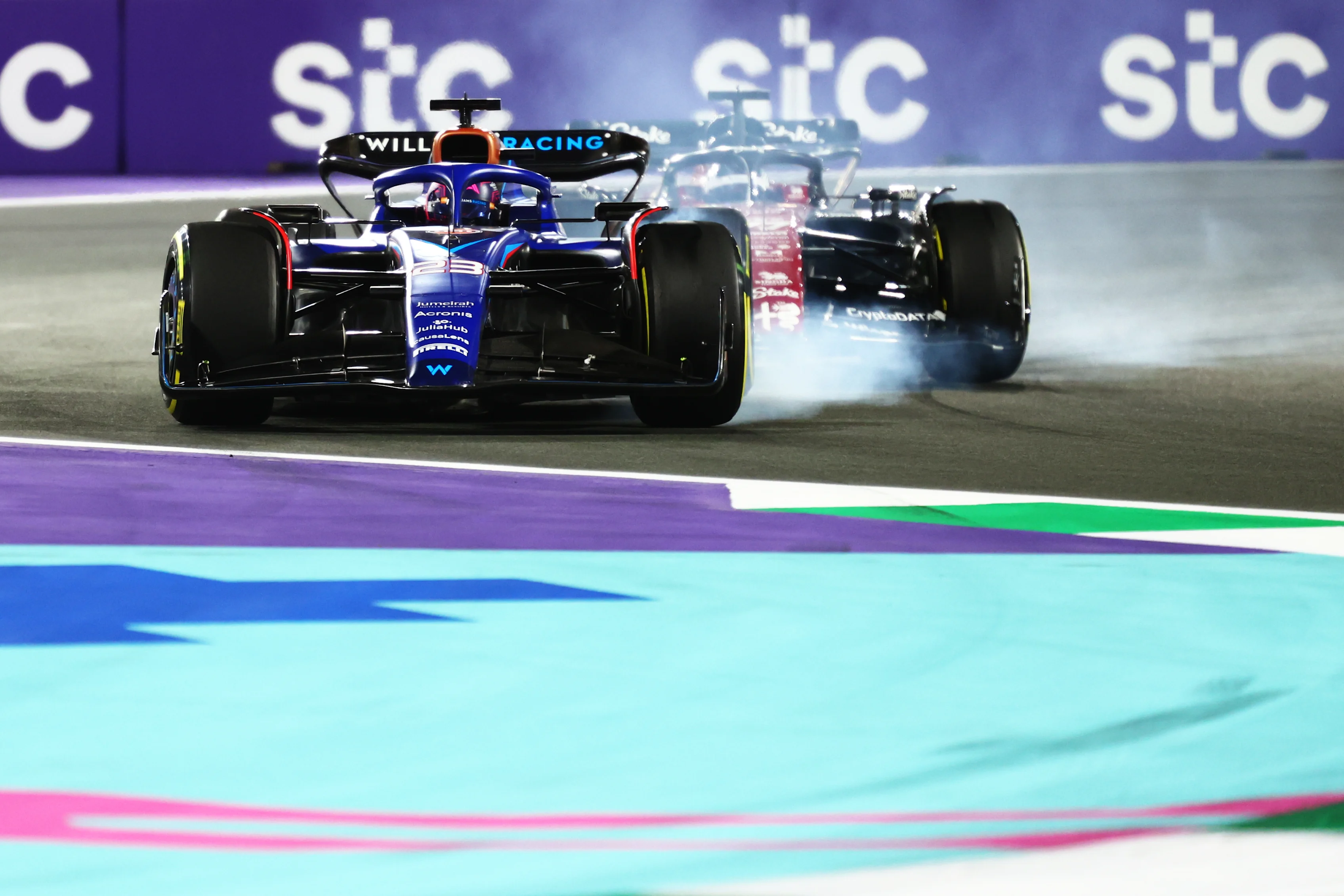JEDDAH, SAUDI ARABIA - MARCH 19: Alexander Albon of Thailand driving the (23) Williams FW45 Mercedes locks a wheel under braking in front of Valtteri Bottas of Finland driving the (77) Alfa Romeo F1 C43 Ferrari during the F1 Grand Prix of Saudi Arabia at Jeddah Corniche Circuit on March 19, 2023 in Jeddah, Saudi Arabia. (Photo by Dan Istitene - Formula 1/Formula 1 via Getty Images)