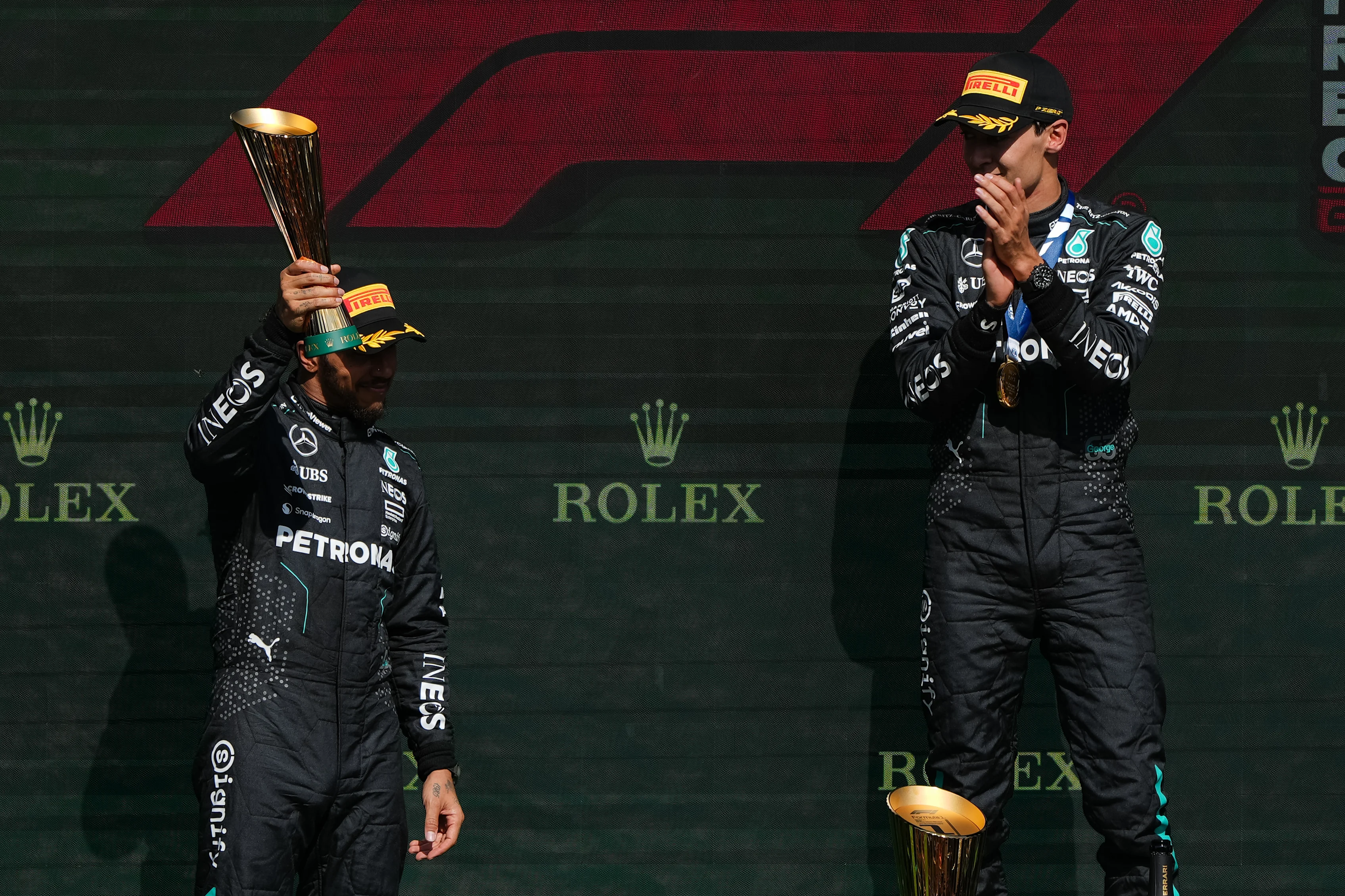 SPA, BELGIUM - JULY 28: 1st placed finisher George Russell, later disqualified for a car weight infraction (R), Lewis Hamilton celebrate on the podium during the F1 Grand Prix of Belgium. (Photo by Alex Bierens de Haan/Getty Images)