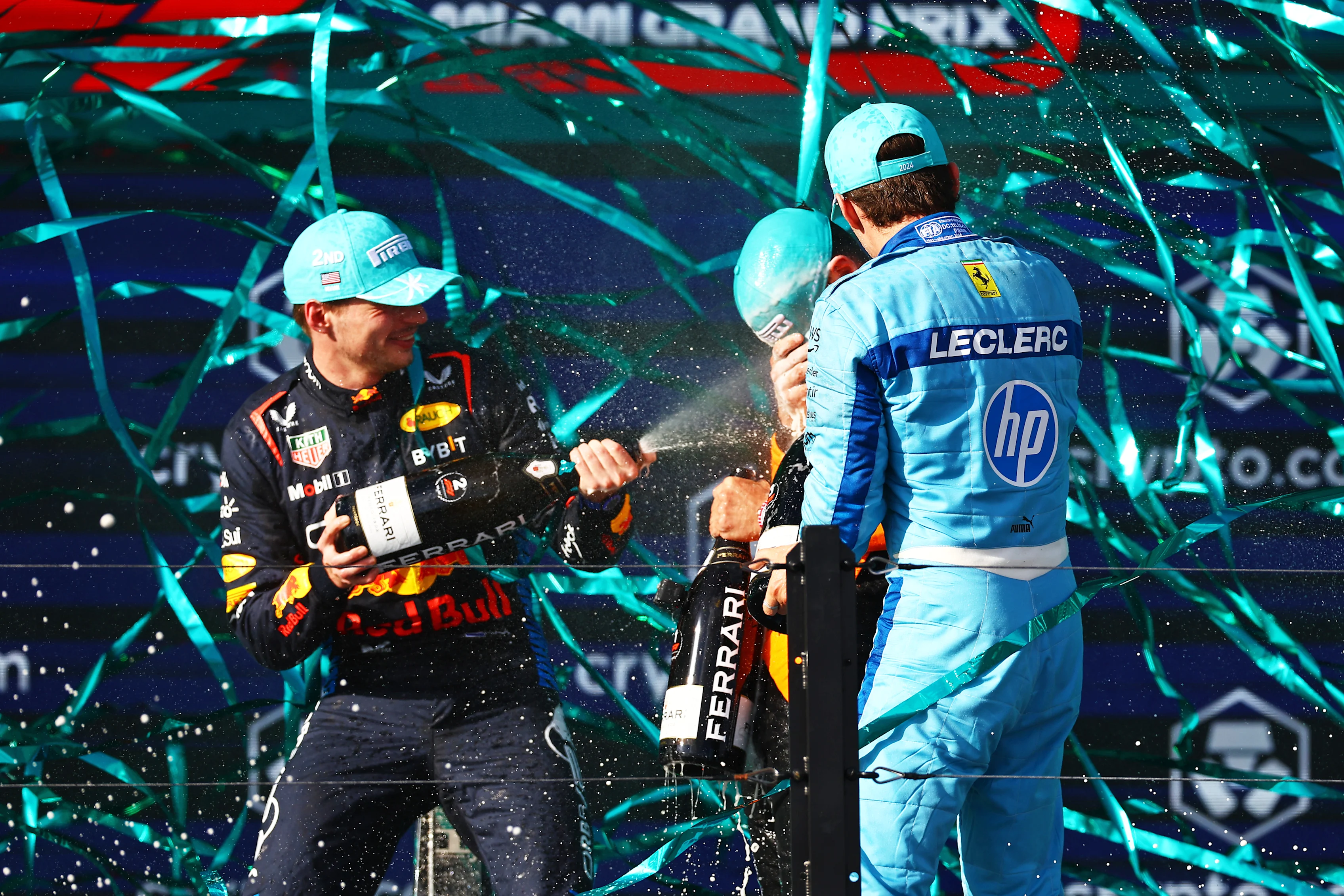 MIAMI, FLORIDA - MAY 05: Second placed Max Verstappen of the Netherlands and Oracle Red Bull Racing and Third placed Charles Leclerc of Monaco and Ferrari celebrate with Race winner Lando Norris of Great Britain and McLaren on the podium during the F1 Grand Prix of Miami at Miami International Autodrome on May 05, 2024 in Miami, Florida. (Photo by Mark Thompson/Getty Images)