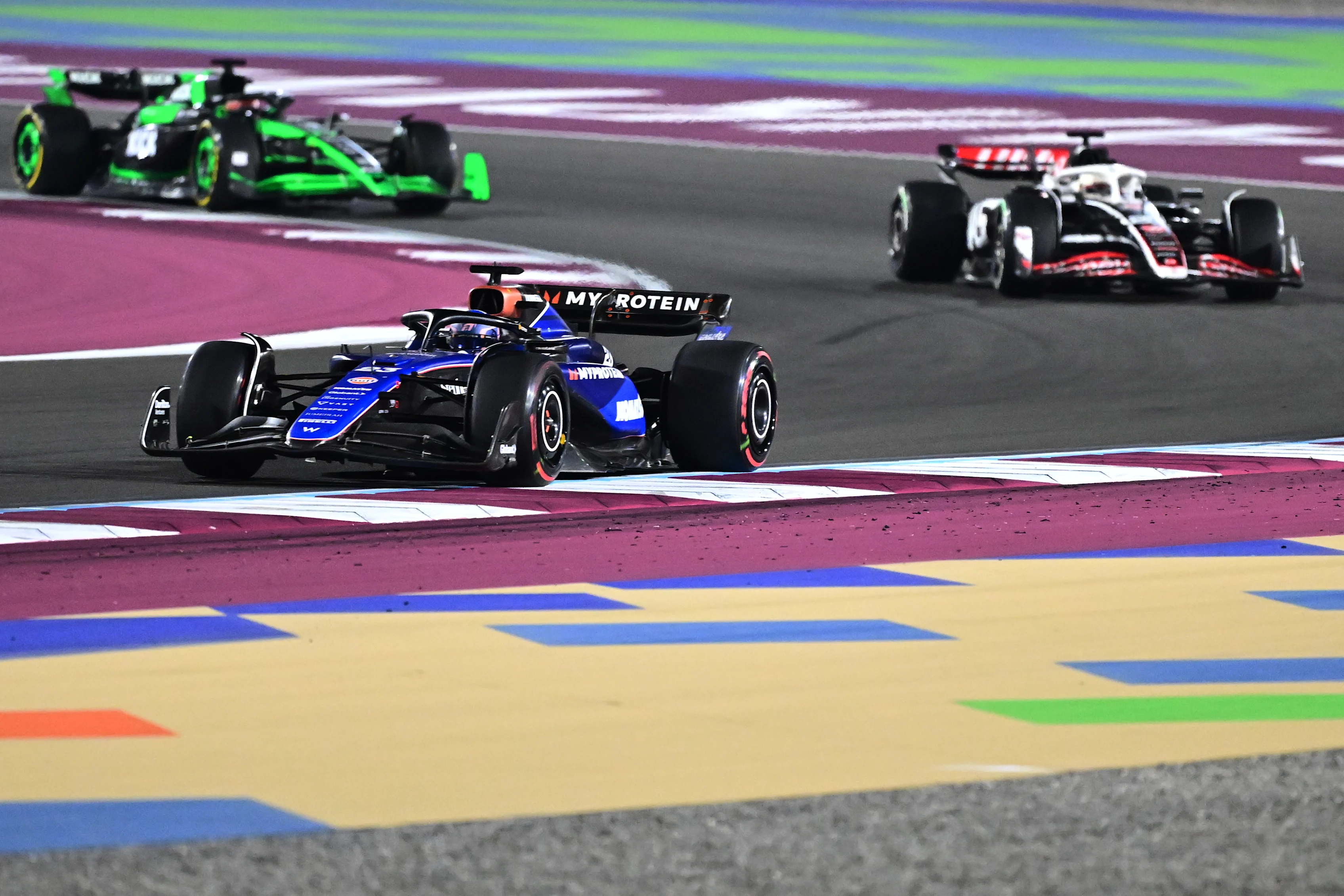 LUSAIL CITY, QATAR - DECEMBER 01: Alexander Albon of Thailand driving the (23) Williams FW46 Mercedes leads Kevin Magnussen of Denmark driving the (20) Haas F1 VF-24 Ferrari and Valtteri Bottas of Finland driving the (77) Kick Sauber C44 Ferrari on track during the F1 Grand Prix of Qatar at Lusail International Circuit on December 01, 2024 in Lusail City, Qatar. (Photo by Pauline Ballet - Formula 1/Formula 1 via Getty Images)