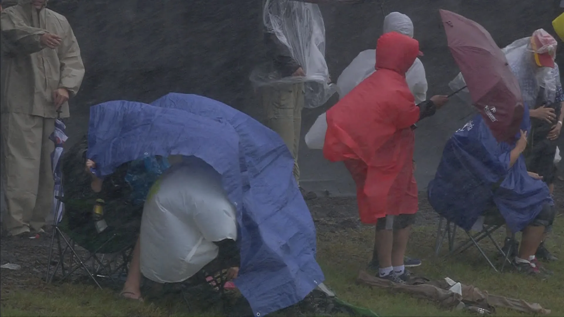 The fans try to shelter from the unrelenting elements