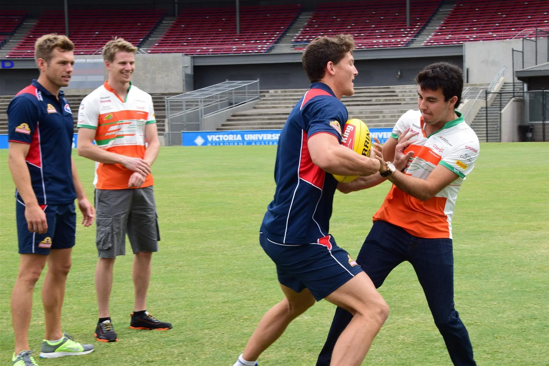 Nico Hulkenberg (GER) Force India F1 and Sergio Perez (MEX) Force India F1 with AFL Premiership Western Bulldogs at Whitten Oval. Formula One World Championship, Rd1, Australian Grand Prix, Preparations, Albert Park, Melbourne, Australia, Tuesday, 11 March 2014