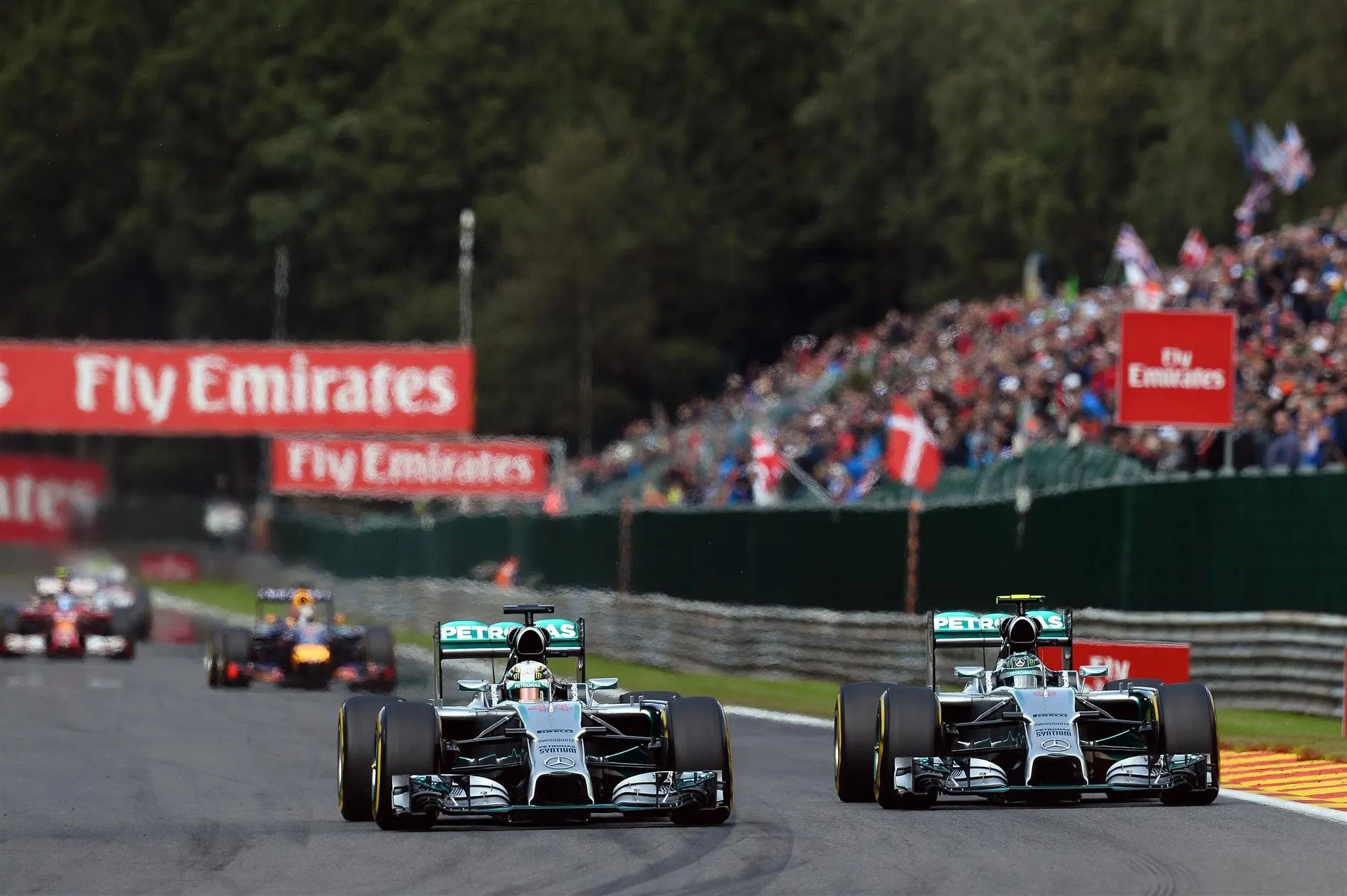 (L to R): Lewis Hamilton (GBR) Mercedes AMG F1 W05 and Nico Rosberg (GER) Mercedes AMG F1 W05 battle at Les Coombes on lap 2. Rosberg damaged his front wing and punctured the left rear wheel of Hamilton's car in the process. Formula One World Championship, Rd12, Belgian Grand Prix, Race Day, Spa-Francorchamps, Belgium, Sunday, 24 August 2014. © Sutton Images