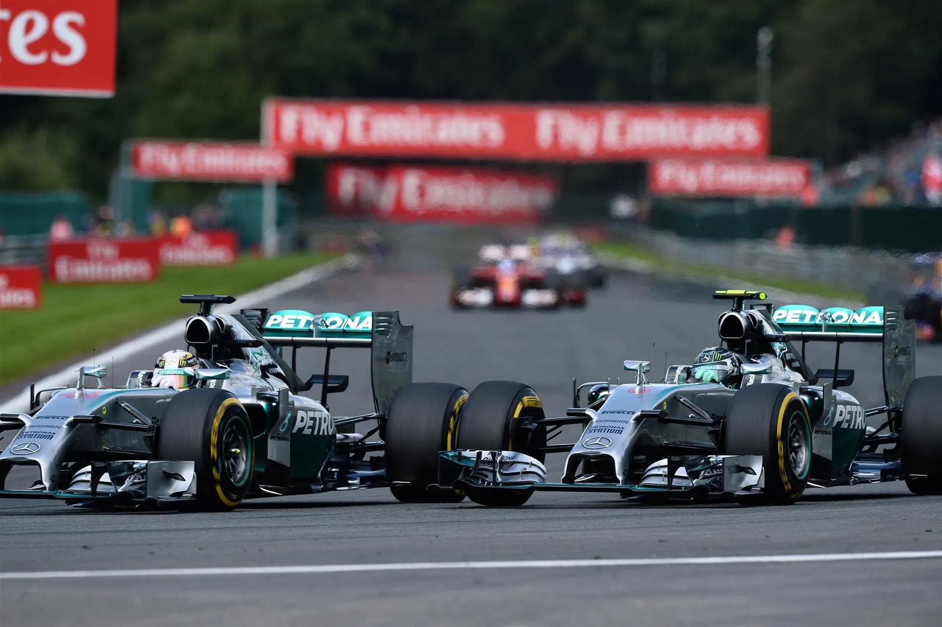 (L to R): Lewis Hamilton (GBR) Mercedes AMG F1 W05 and Nico Rosberg (GER) Mercedes AMG F1 W05 battle at Les Coombes on lap 2. Rosberg damaged his front wing and punctured the left rear wheel of Hamilton's car in the process. Formula One World Championship, Rd12, Belgian Grand Prix, Race Day, Spa-Francorchamps, Belgium, Sunday, 24 August 2014