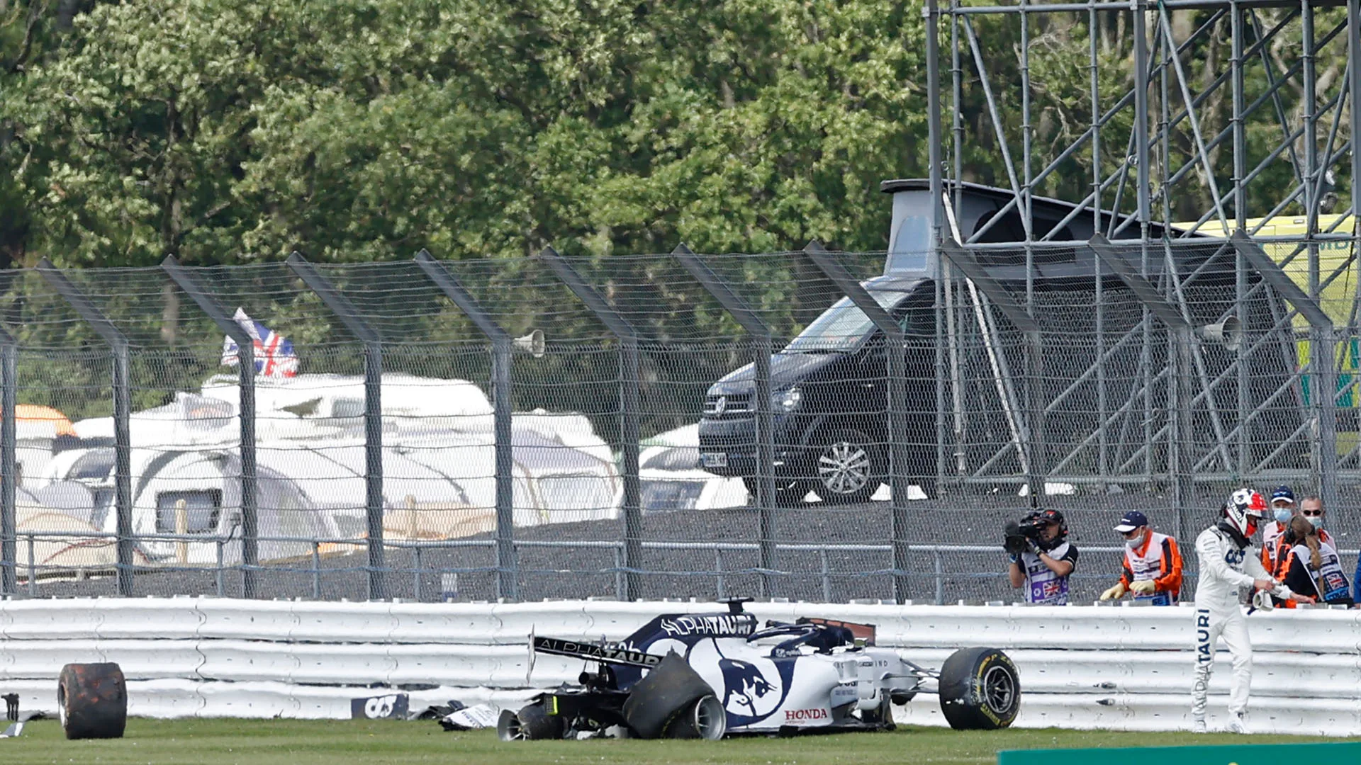 AlphaTauri's Russian driver Daniil Kvyat (R) walks away from his smashed car after a crash during