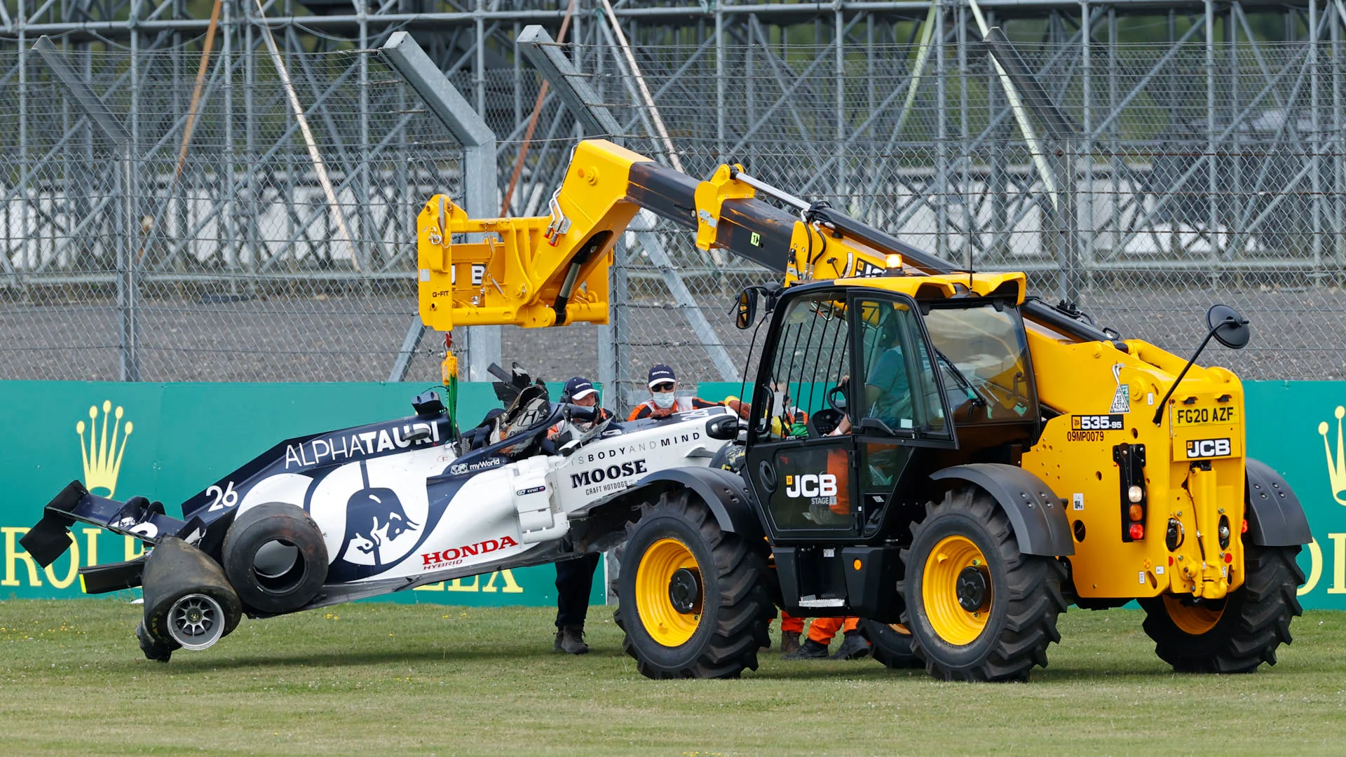 Marshals in face coverings take away the car of AlphaTauri's Russian driver Daniil Kvyat after a crash during the Formula One British Grand Prix at the Silverstone motor racing circuit in Silverstone, central England on August 2, 2020. (Photo by ANDREW BOYERS / POOL / AFP)
