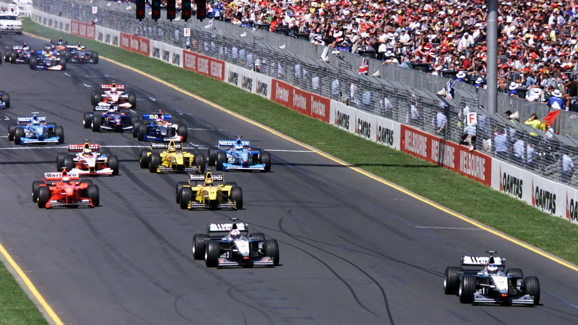 Reigning World Champion Mika Hakkinen (R front row) of Finland powers his McLaren-Mercedes ahead of